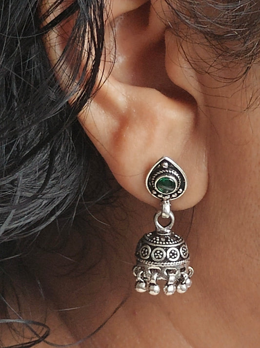 Silver jhumkis (earrings) on a stud with emerald green stone