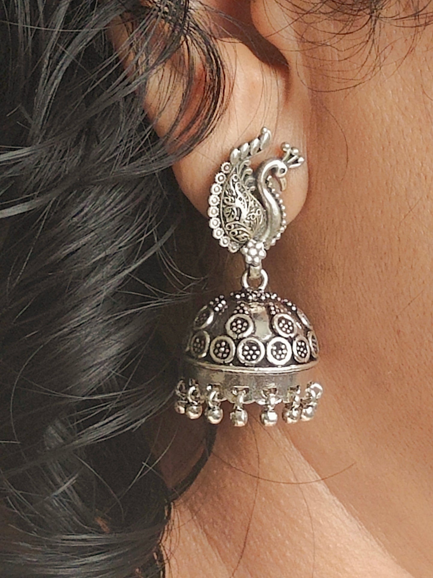 Silver jhumkas (earrings) on peacock stud, hanging ghungroos at the bottom