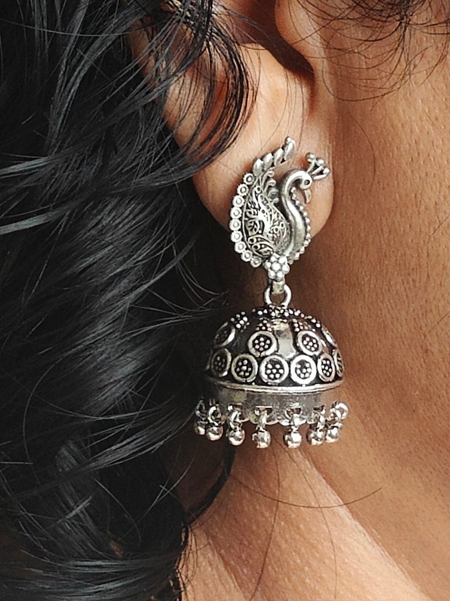 Silver jhumkas (earrings) on peacock stud, hanging ghungroos at the bottom