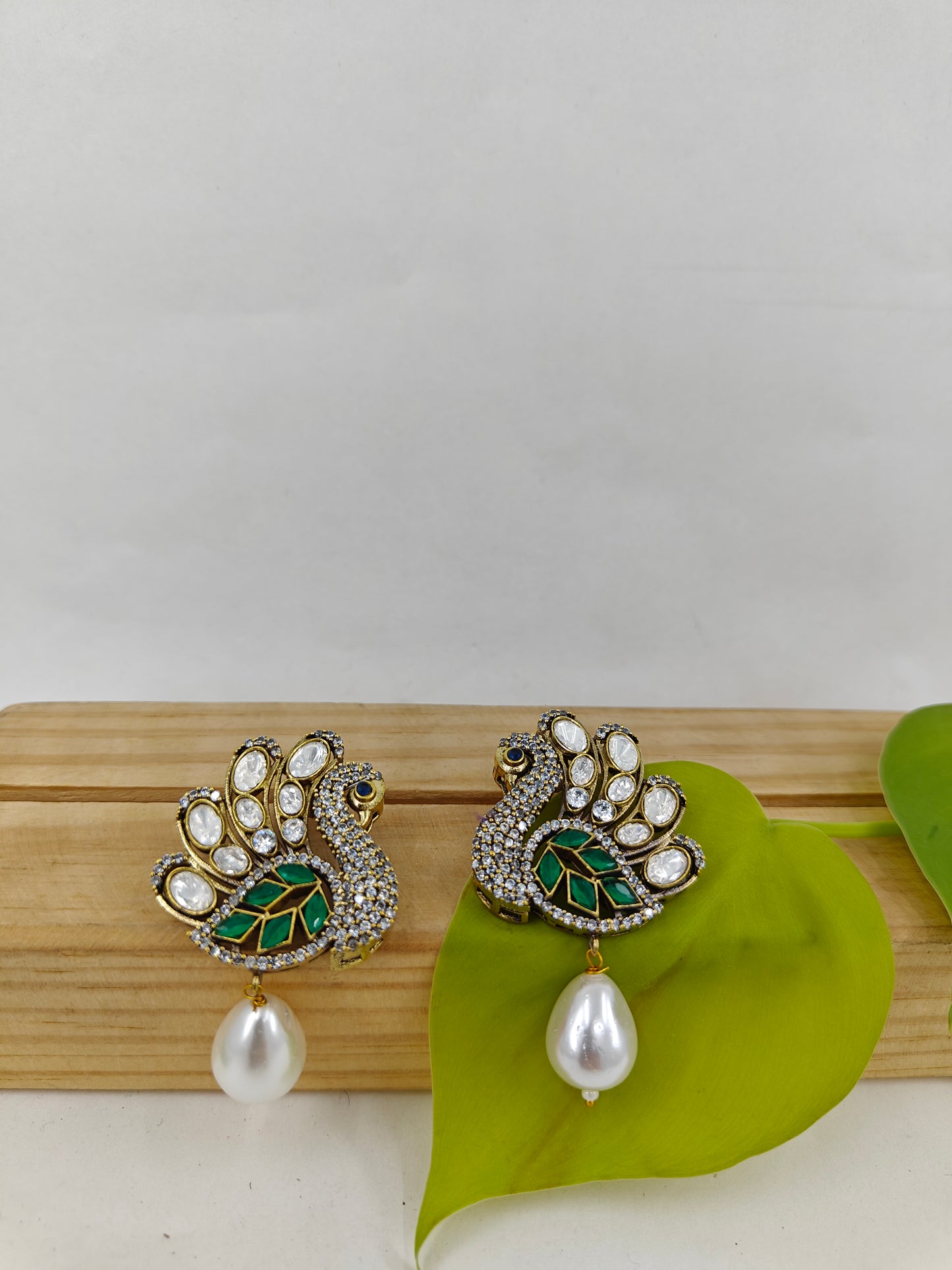 Peacock stud earrings with kundan studded 'feathers' and a pearl drop