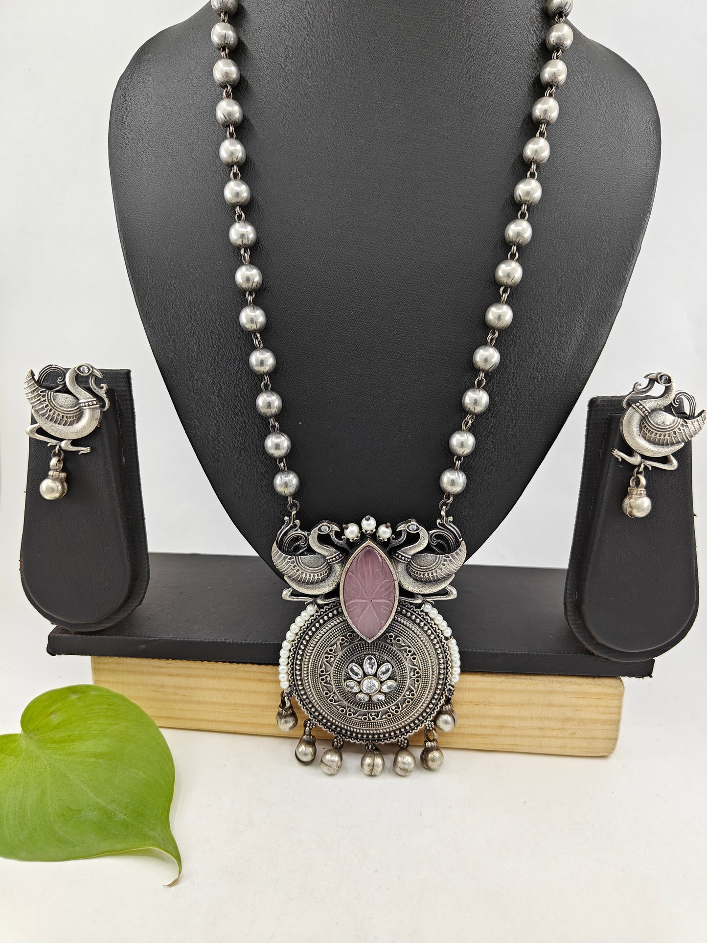 Set in antique silver finish with peacocks and a pink stone pendant on a bead chain