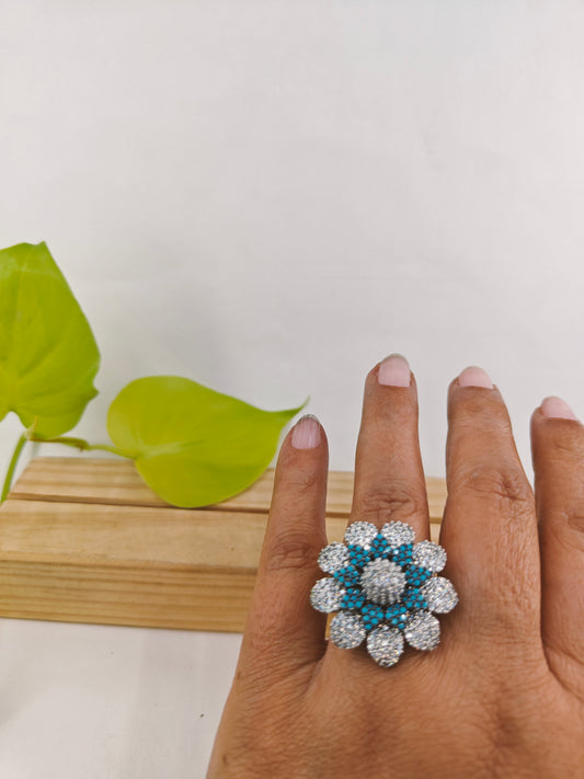 Ring in antique finish in a flower design with nano blue stones on Platinum CZ petals