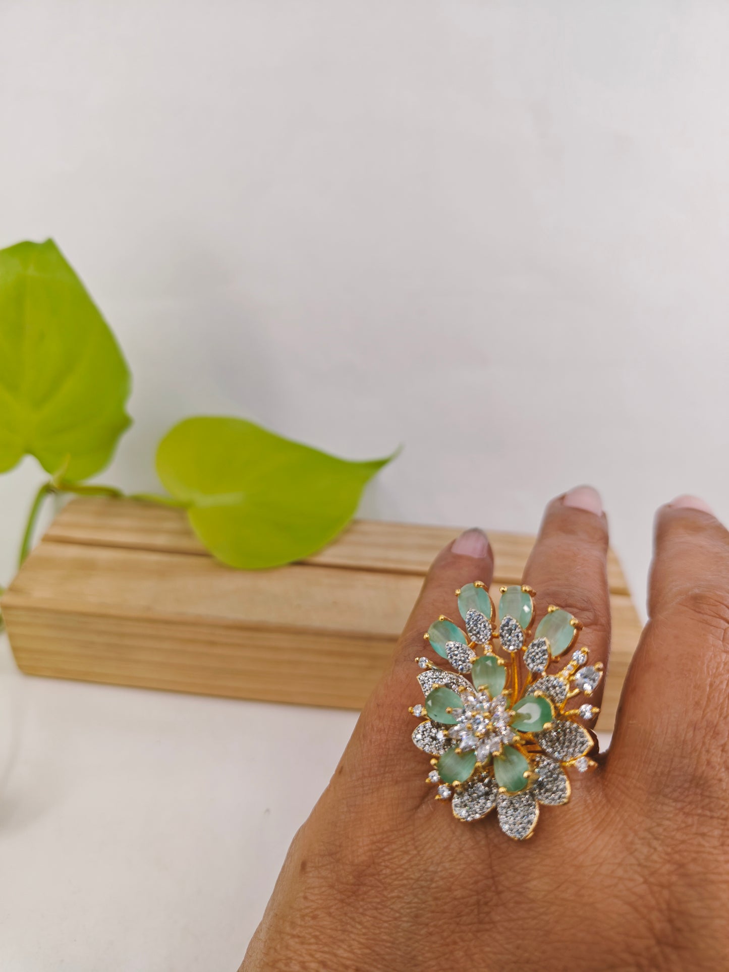 Gold finish ring with mint green and CZ flower design