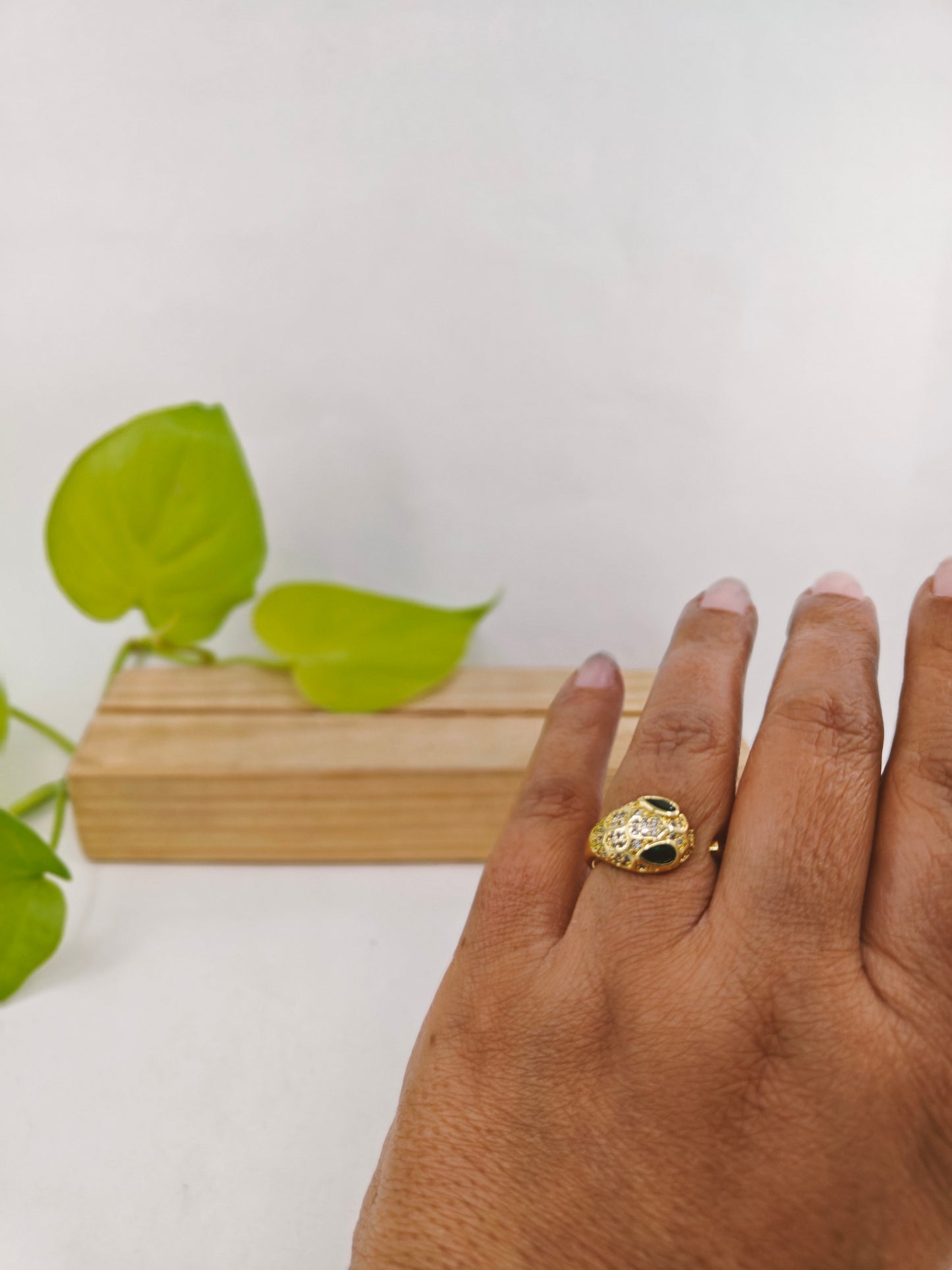 Gold finish snake ring with green eyes and CZ highlights