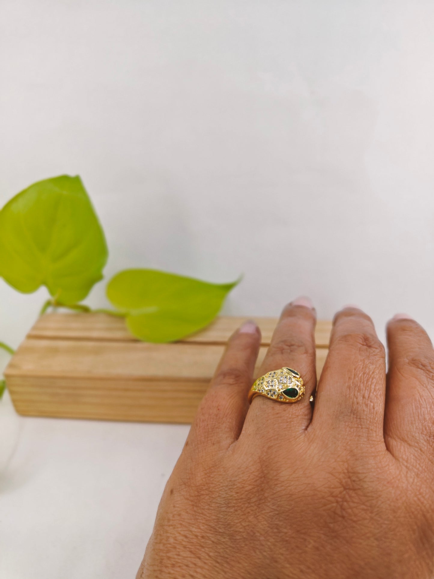 Gold finish snake ring with green eyes and CZ highlights