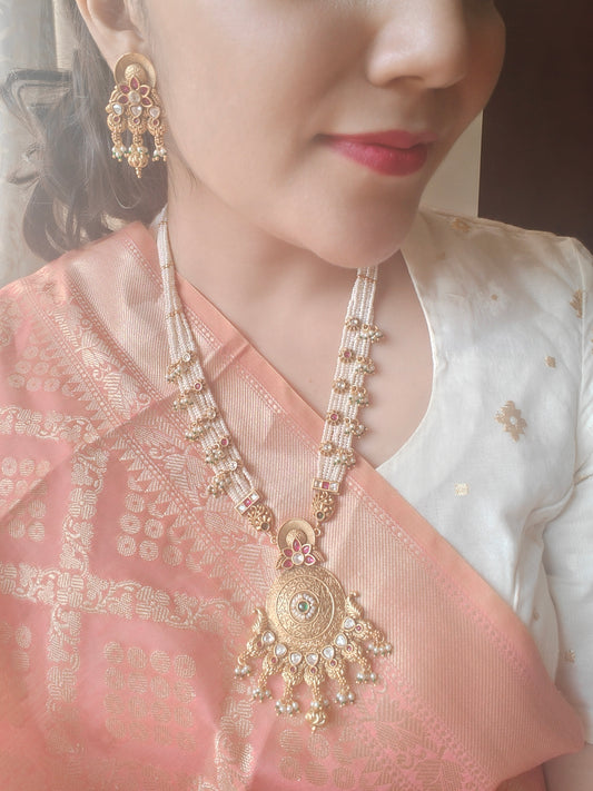 A kundan and pearl work set with a gold finish pendant on poth pearl strings with pachi kundan work