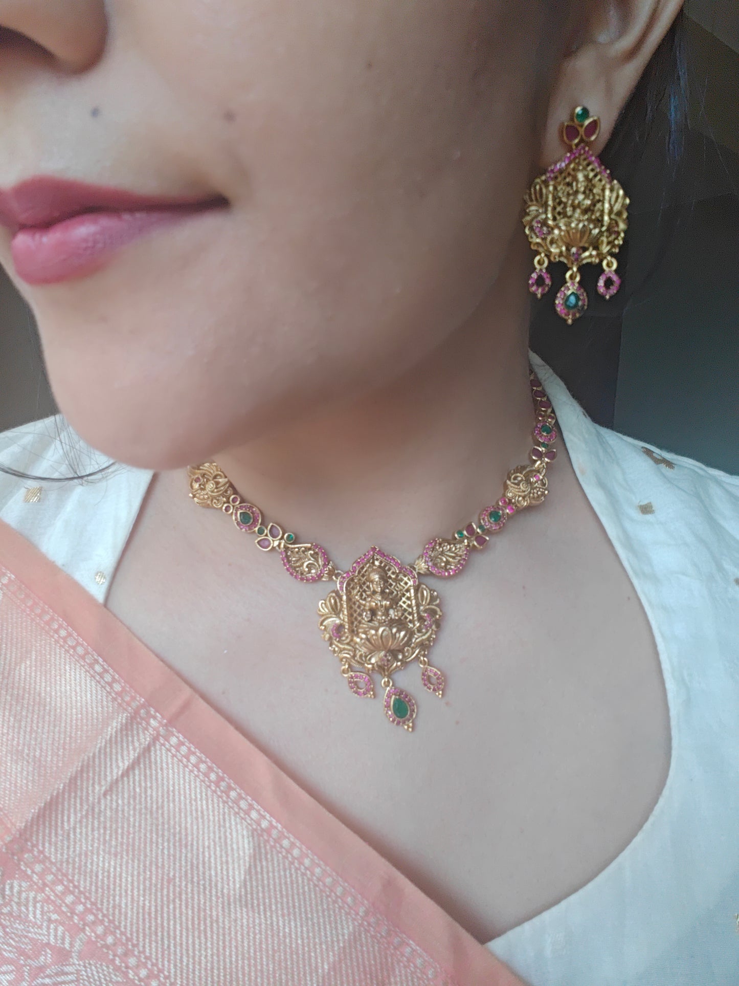 A delicate Temple Jewelry set with Lakshmi pendant with ruby red/CZ stone highlights