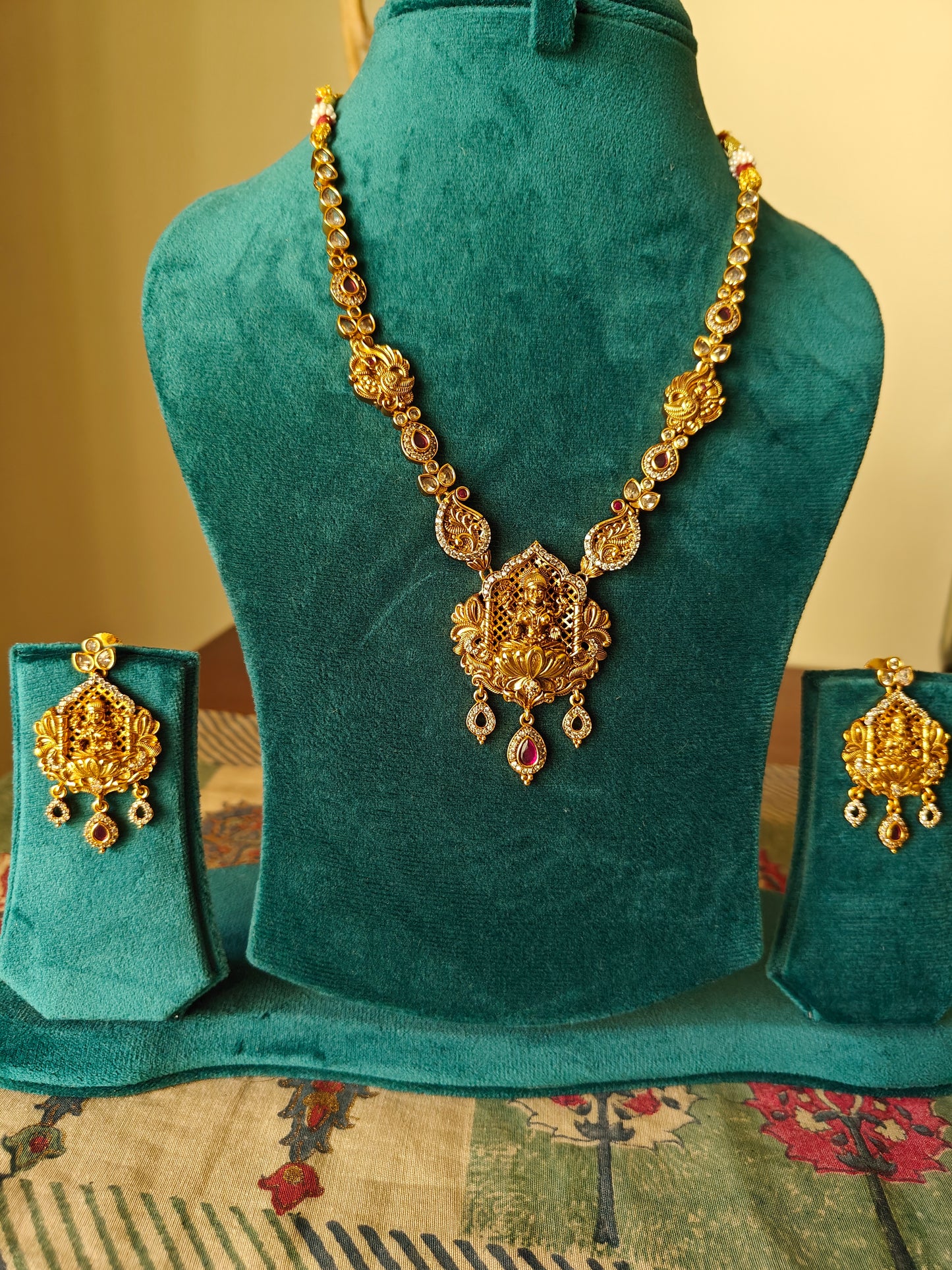 A delicate Temple Jewelry set with Lakshmi pendant with ruby red/CZ stone highlights