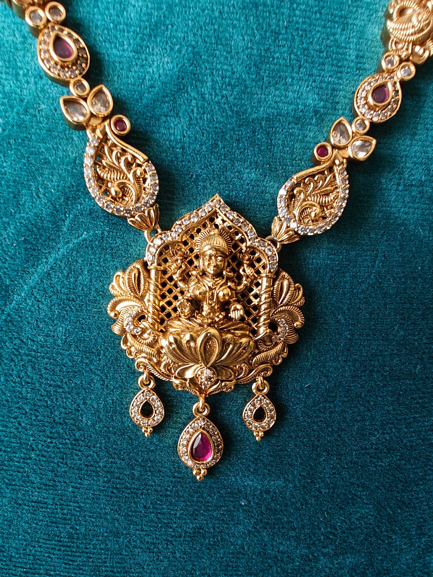 A delicate Temple Jewelry set with Lakshmi pendant with ruby red/CZ stone highlights