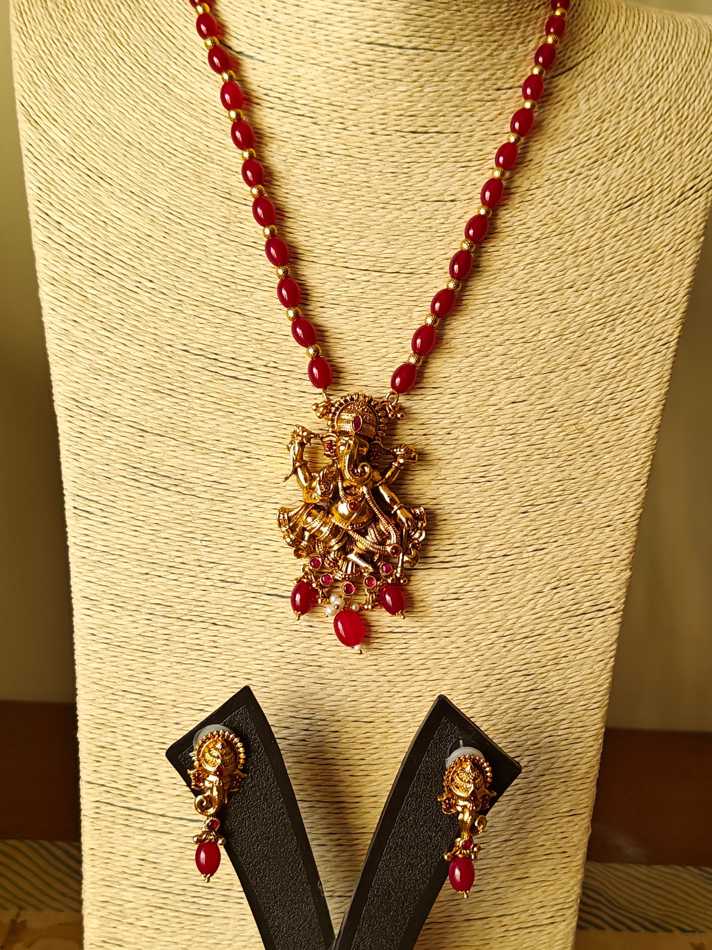 Gold finish Temple set ,carved Ganesha with red stone highlights on red bead necklace.