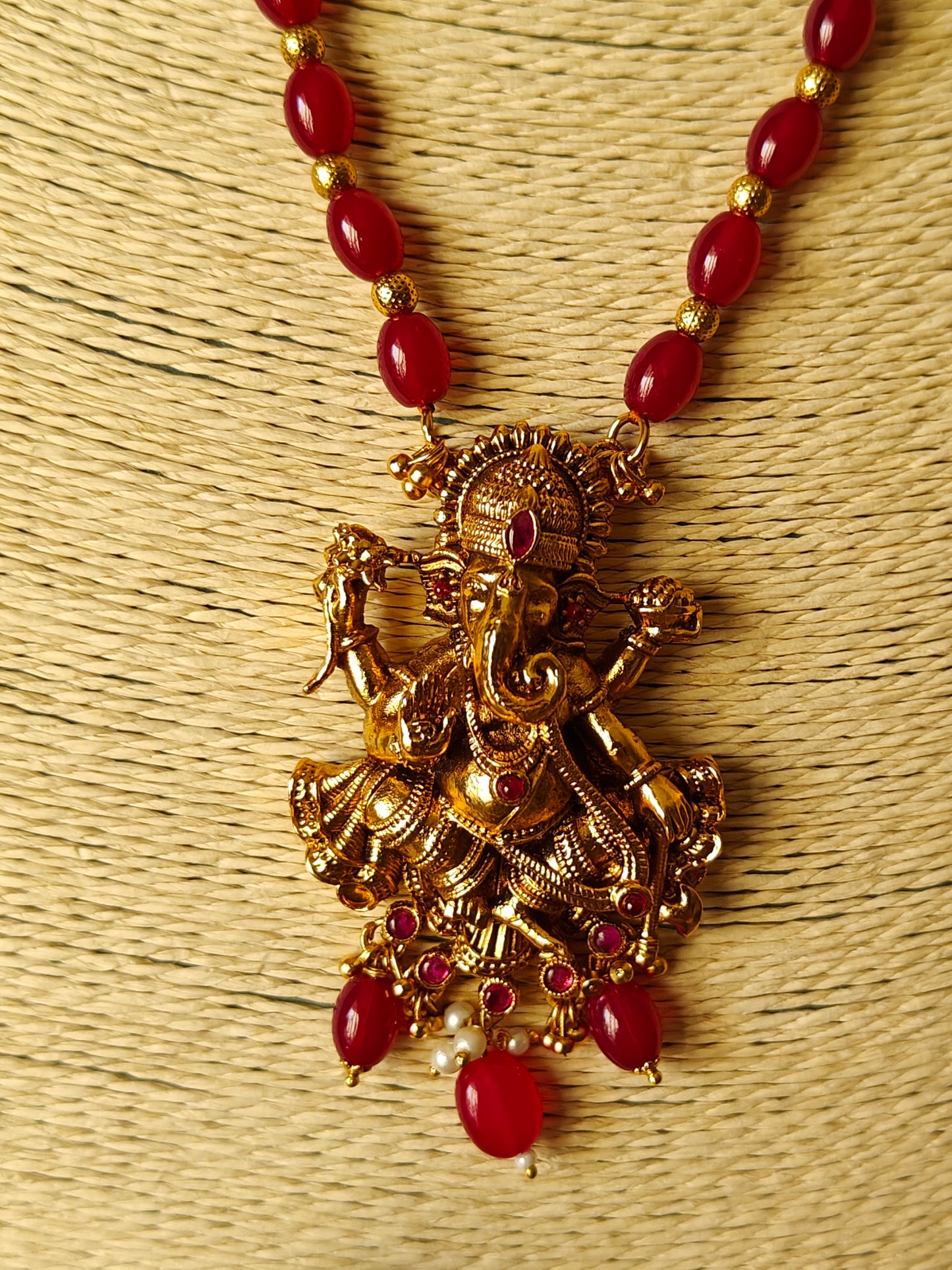 Gold finish Temple set ,carved Ganesha with red stone highlights on red bead necklace.