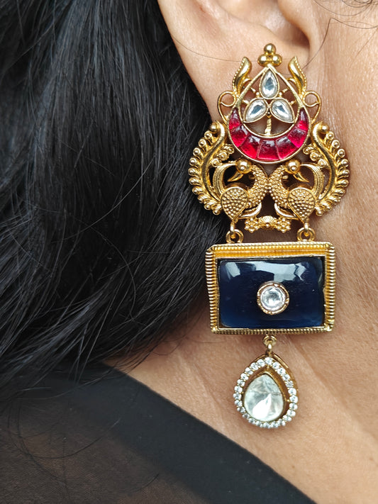 Golden earrings with two peacock motif and black and red stone highlighted with kundan