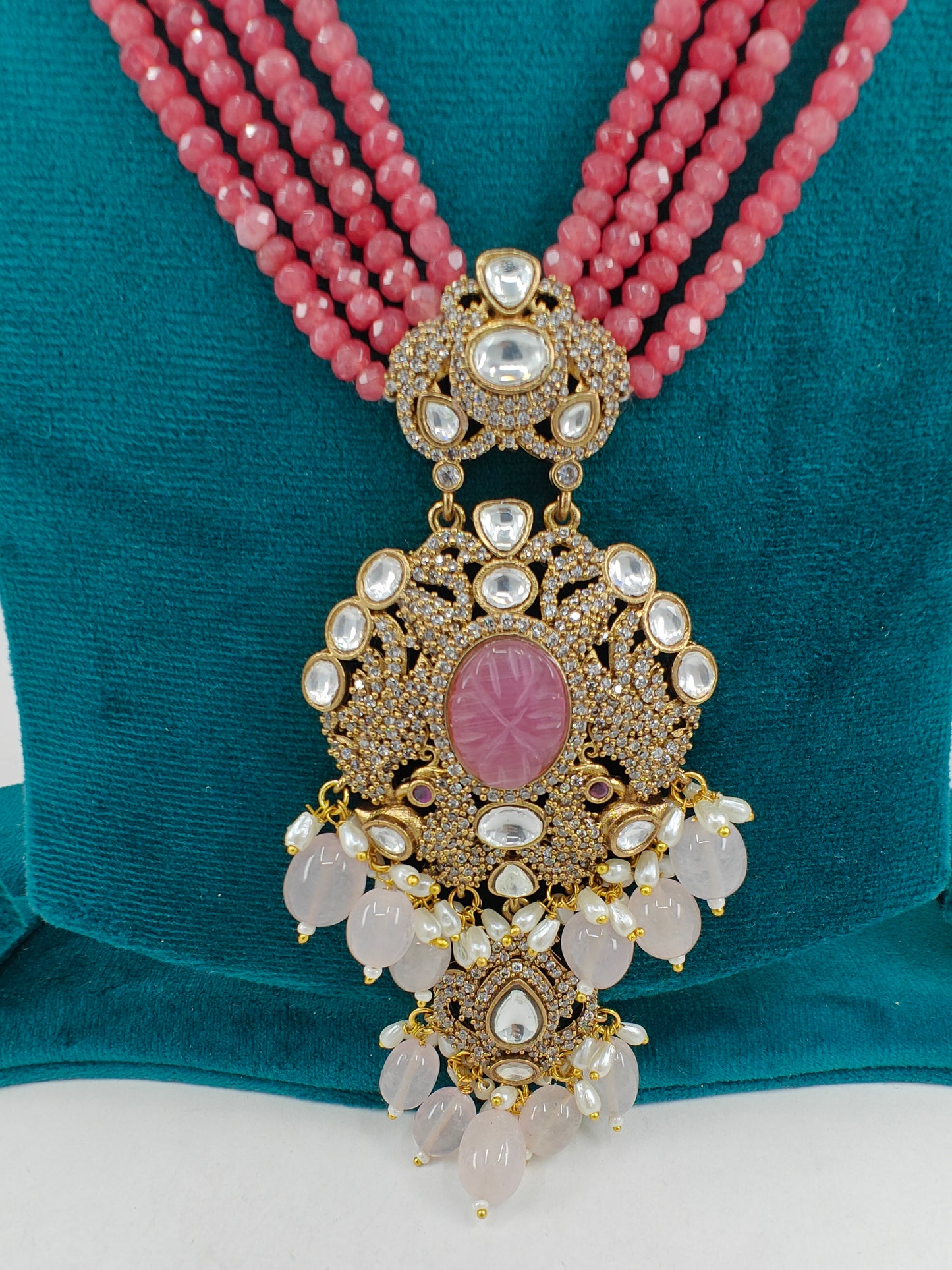 Set in gajari/ peach stone strings with a peacock  motif pendant