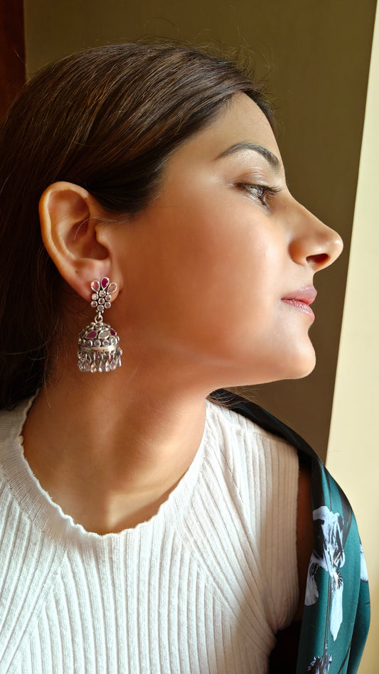 Silver jhumkis (earrings) with red and transparent stone inlay