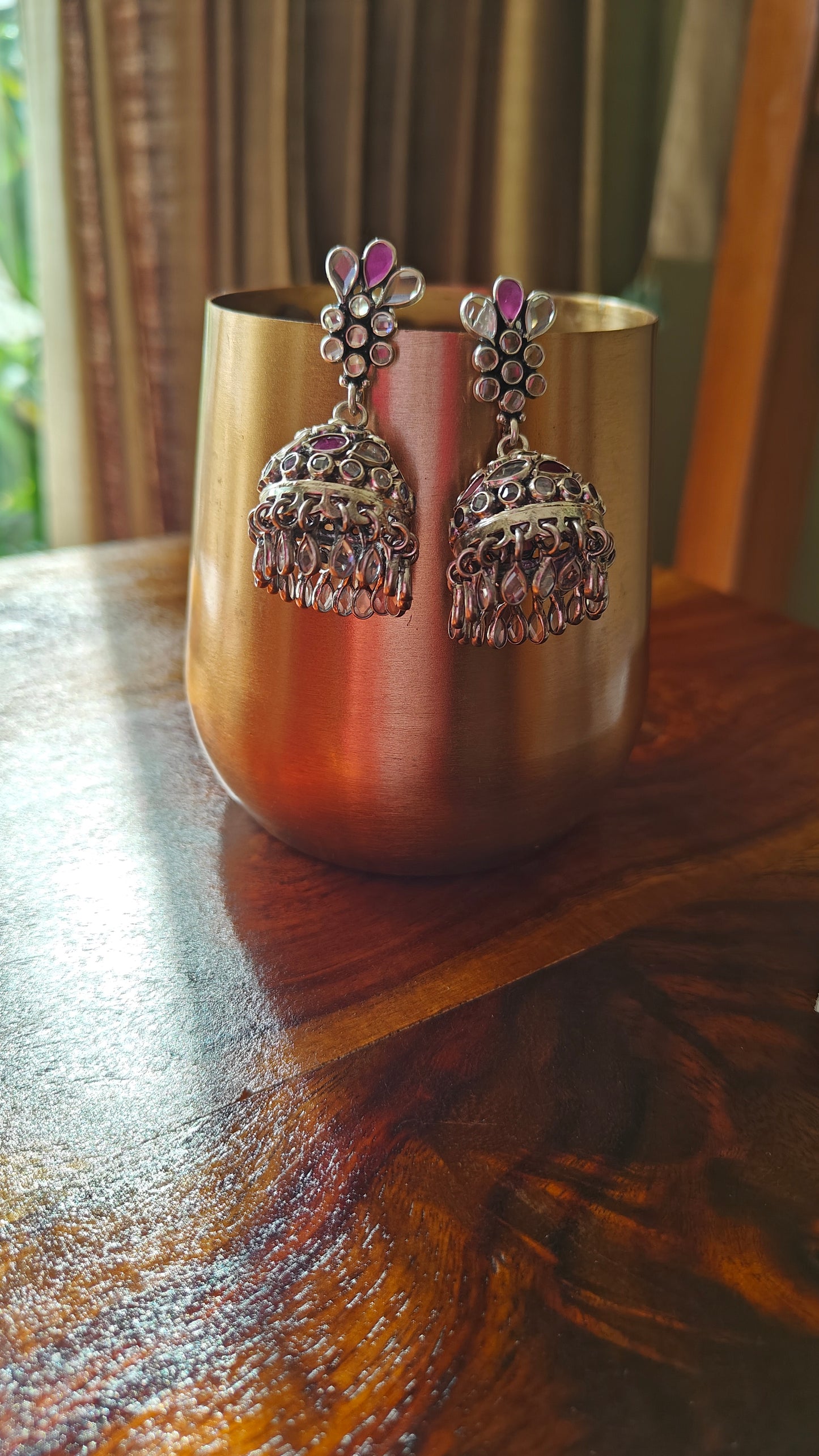 Silver jhumkis (earrings) with red and transparent stone inlay