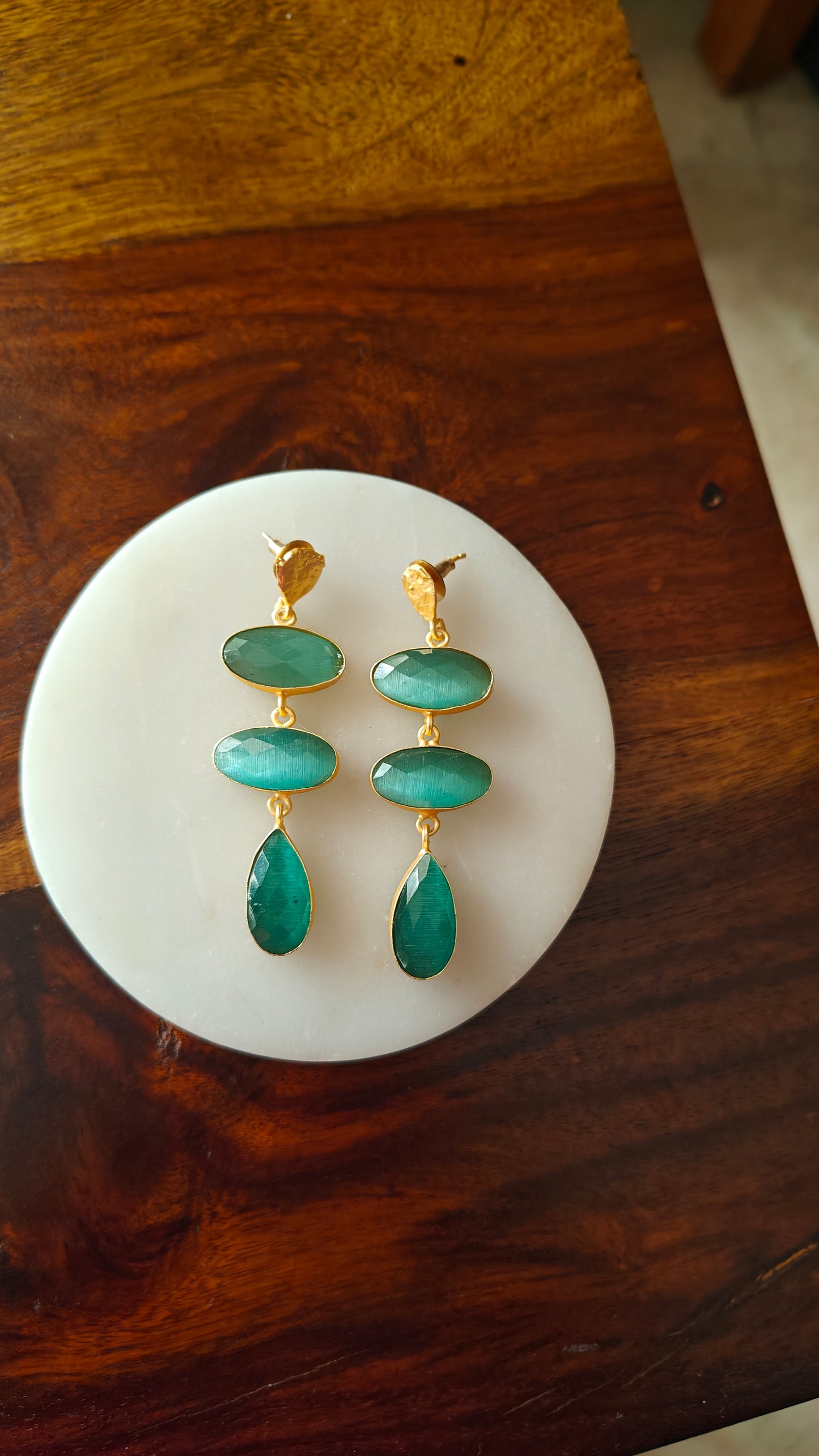 Hanging earrings in a golden frame with stones.