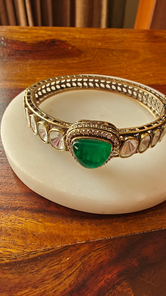 Bangle (kara) with a emerald green stone and kundan