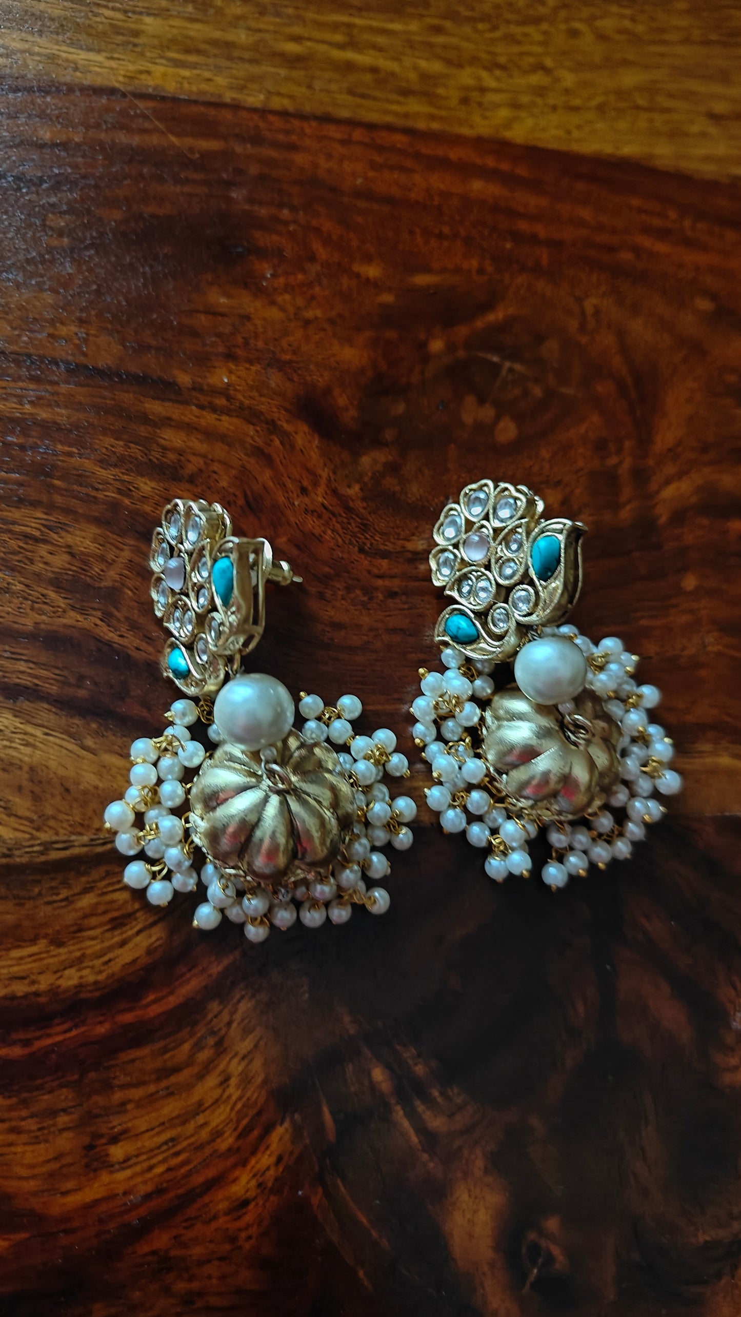 Golden jhumkas on kundan work flower stud