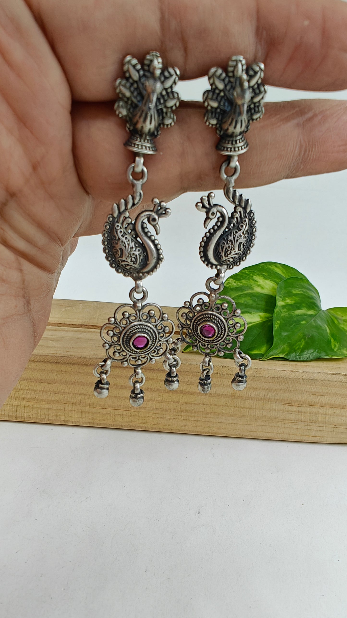 Silver earrings with a open peacock stud and bead hangings below