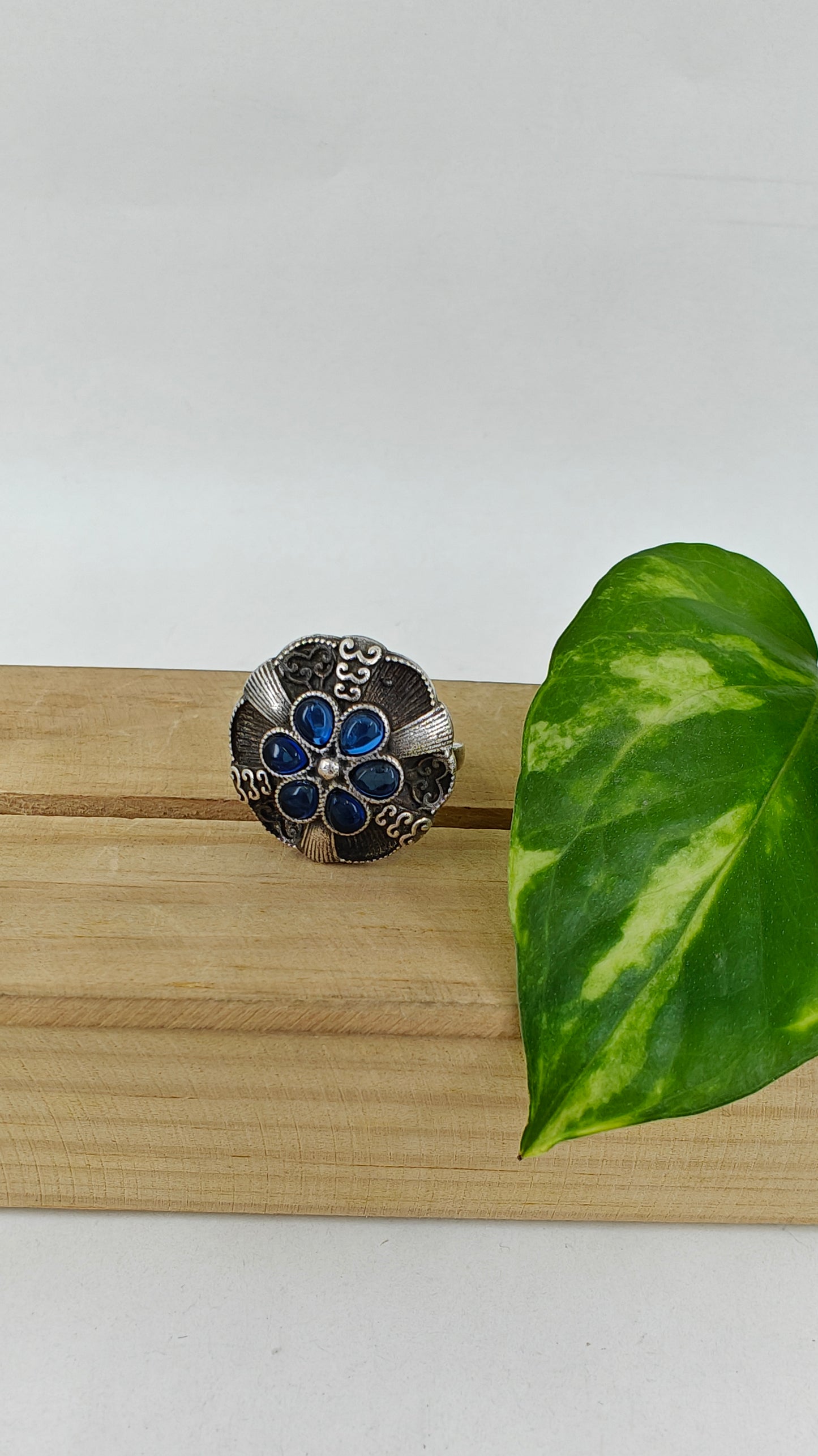 Silver ring with a raised flower with stones