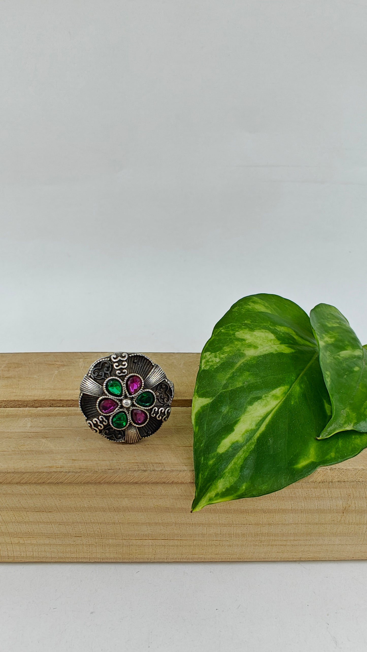 Silver ring with a raised flower with stones