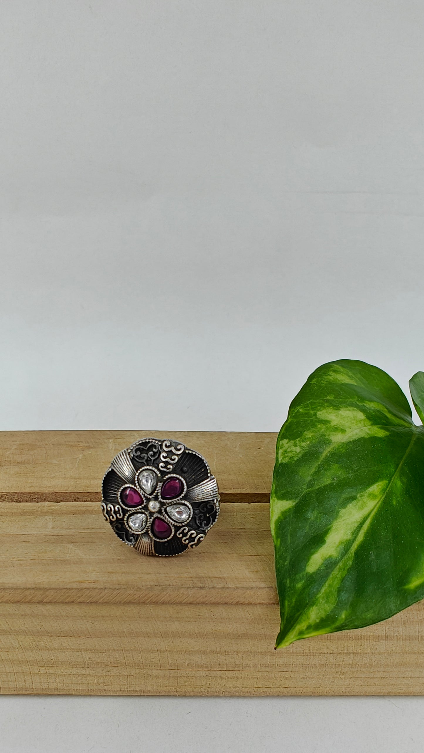 Silver ring with a raised flower with stones