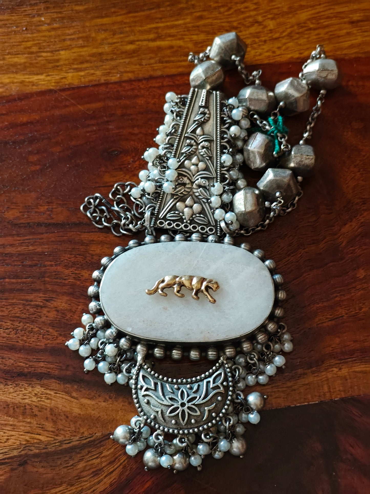 Necklace with stone pendant with a tiger motif on it