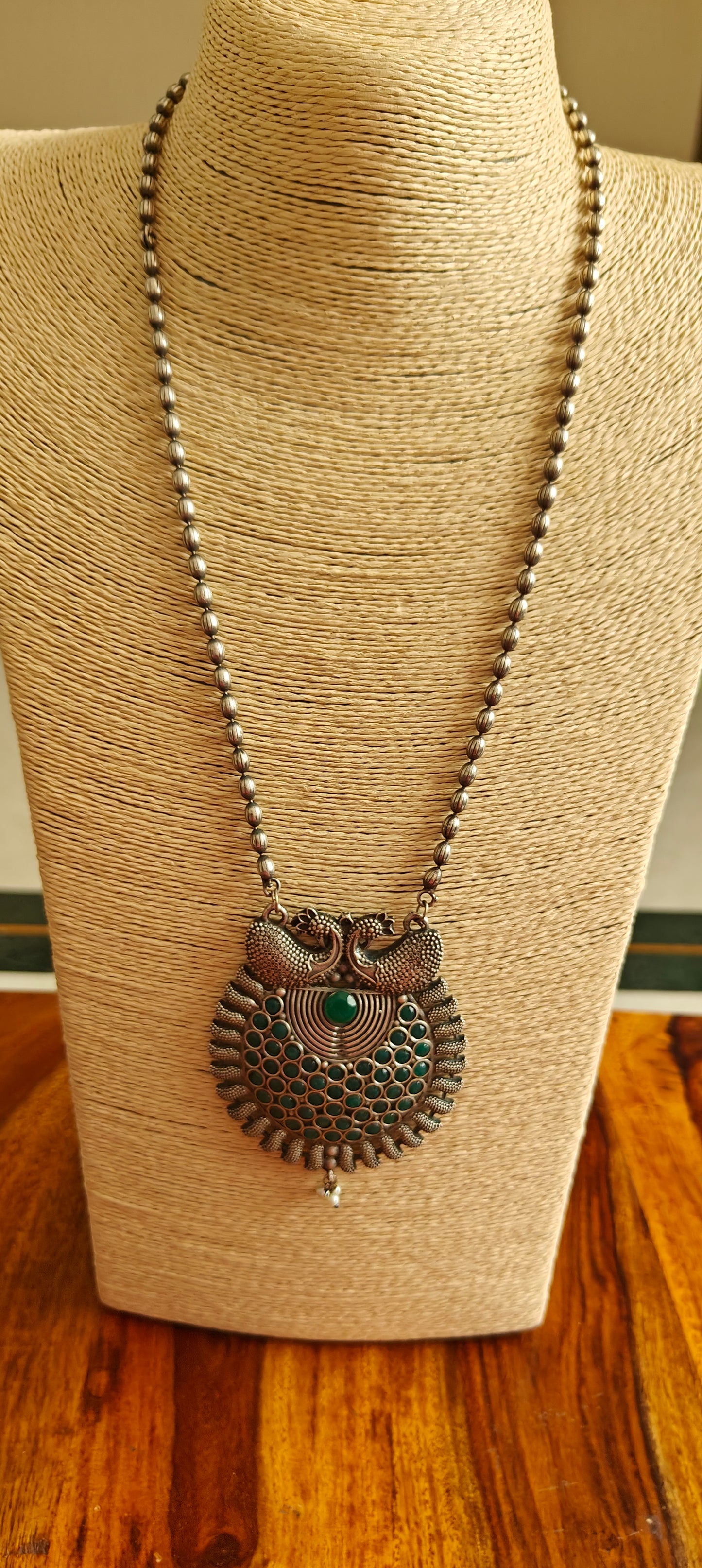 Necklace with green stone and peacock pendant