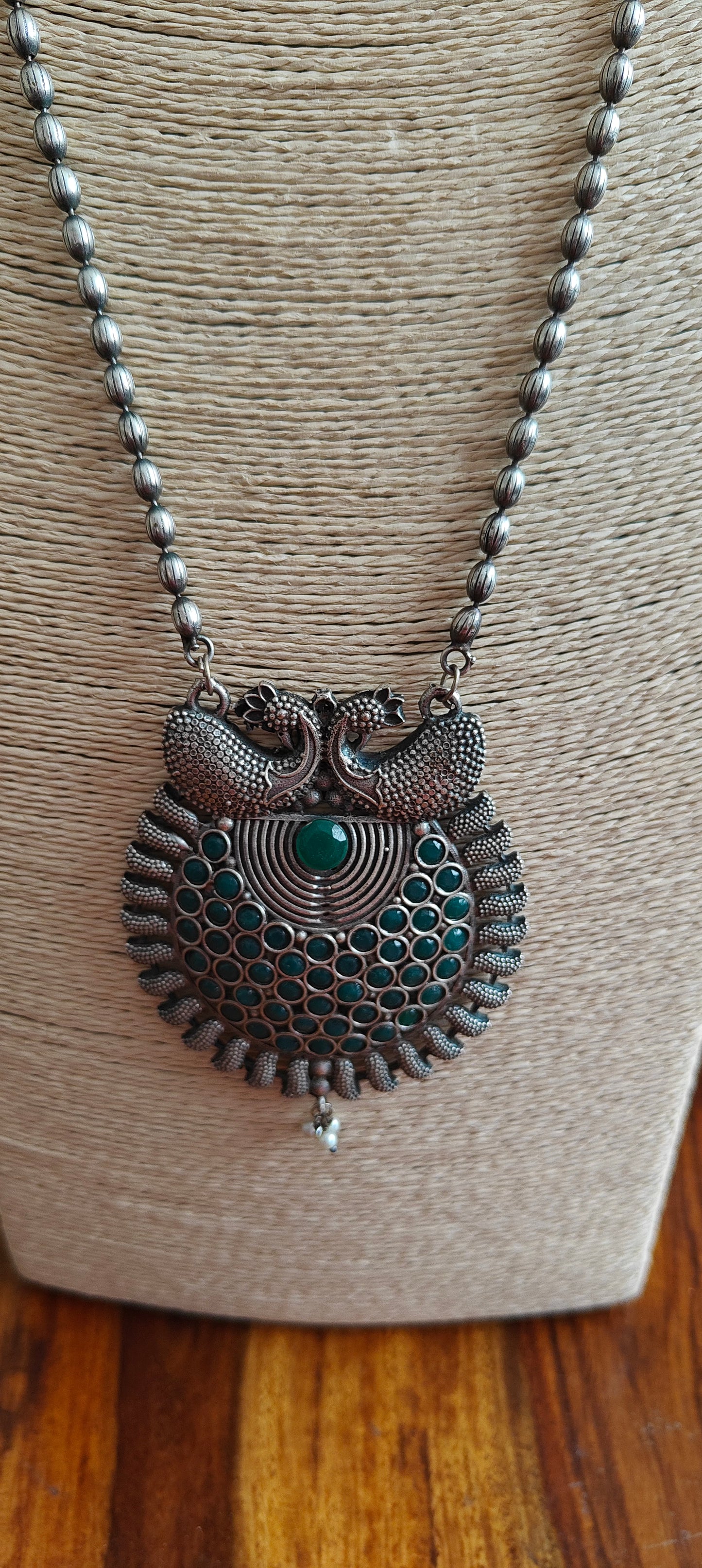 Necklace with green stone and peacock pendant