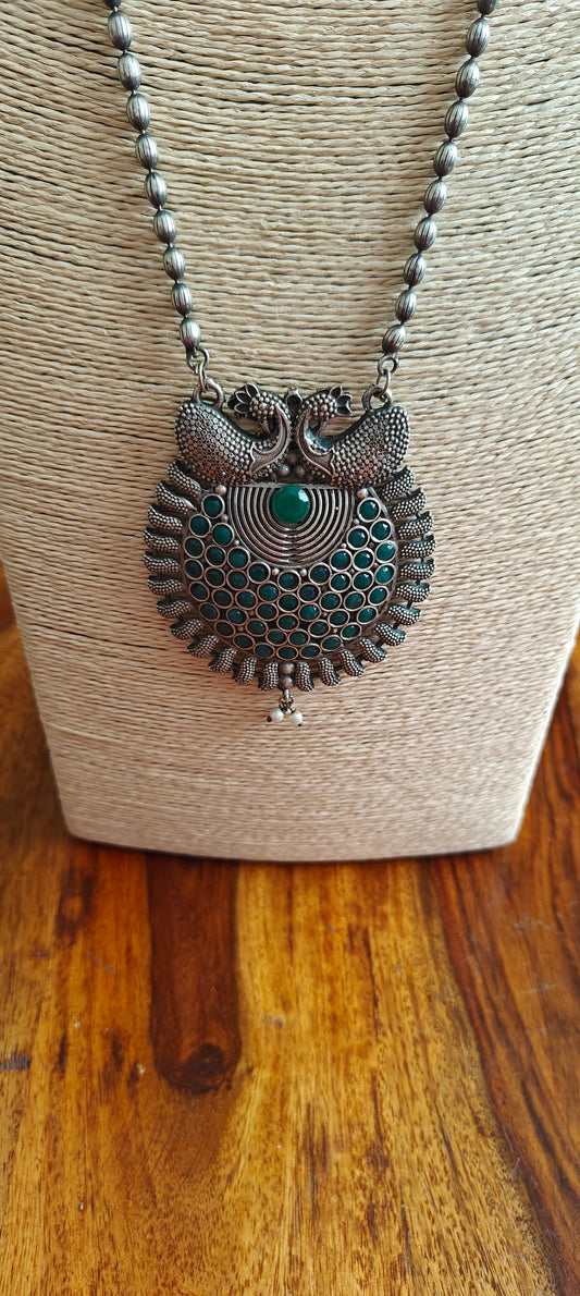 Necklace with green stone and peacock pendant