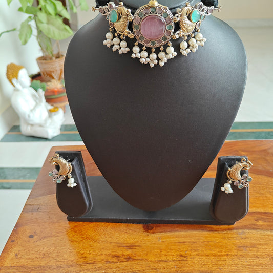 Dual tone choker set with a stone central piece and peacocks