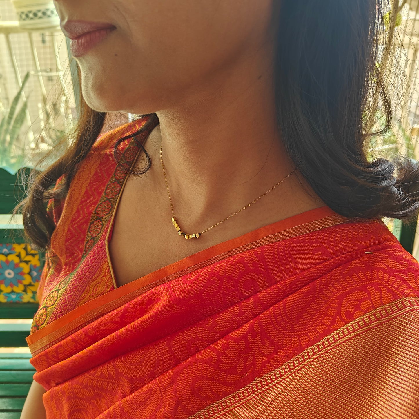 Gold chain with square  pieces on it in centre