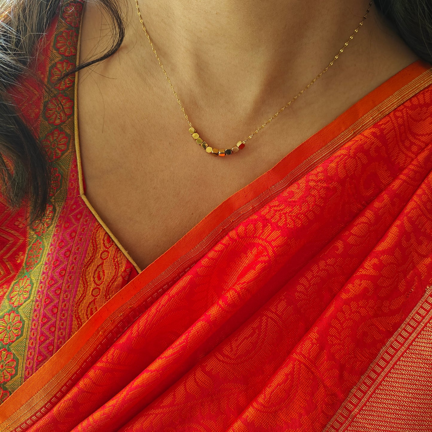 Gold chain with square  pieces on it in centre