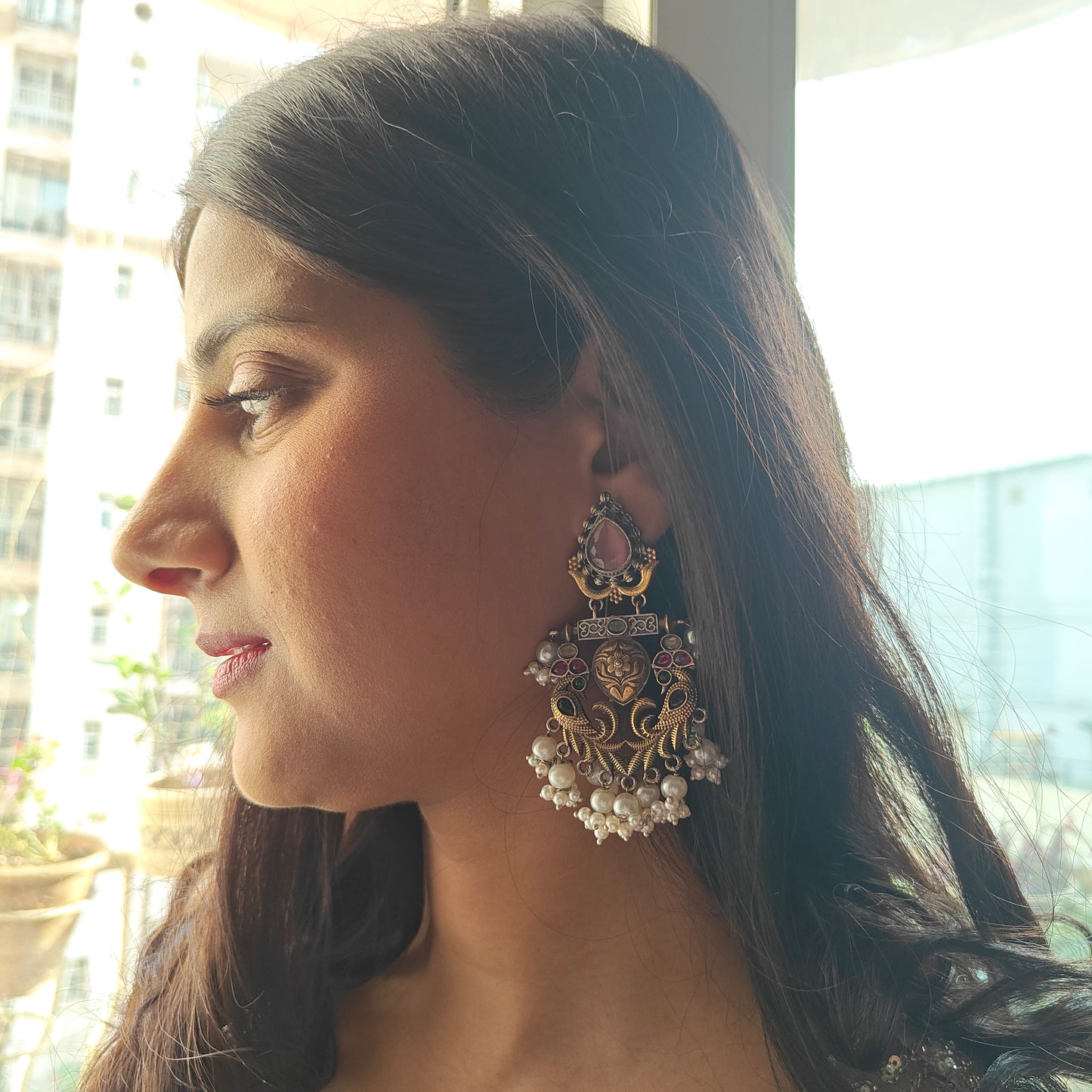 Dual tone earrings with peacocks and pink stone