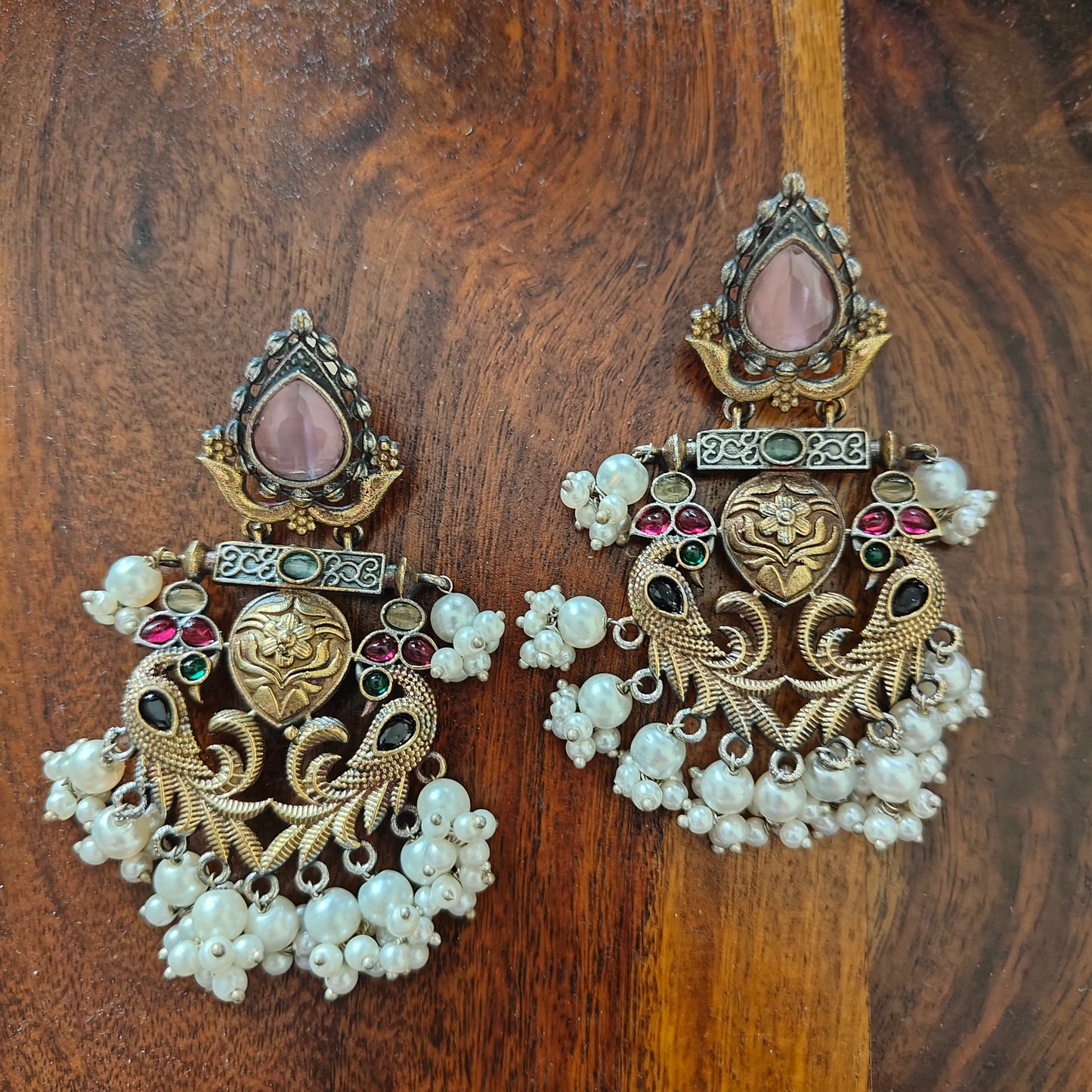 Dual tone earrings with peacocks and pink stone