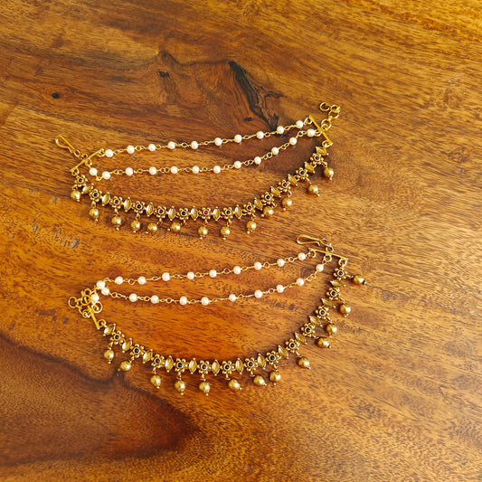 Ear chains with golden flowers and hanging golden balls.