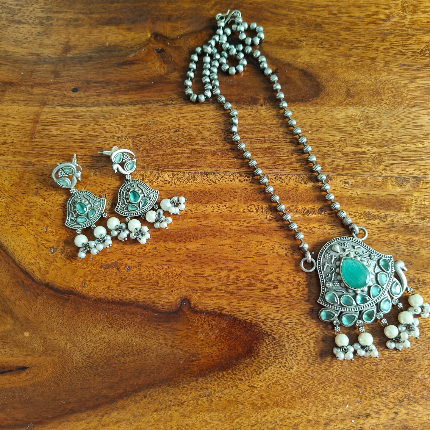 Set with peacock motif and stones