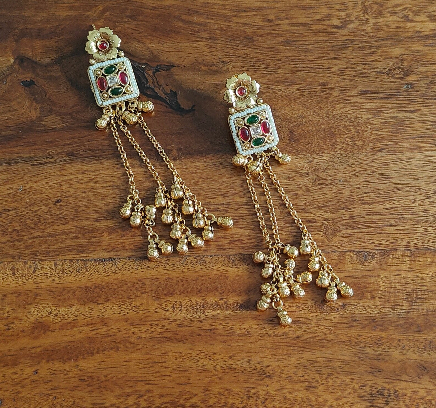 Gold earrings with hanging chains and gold balls below square with pearls and stone