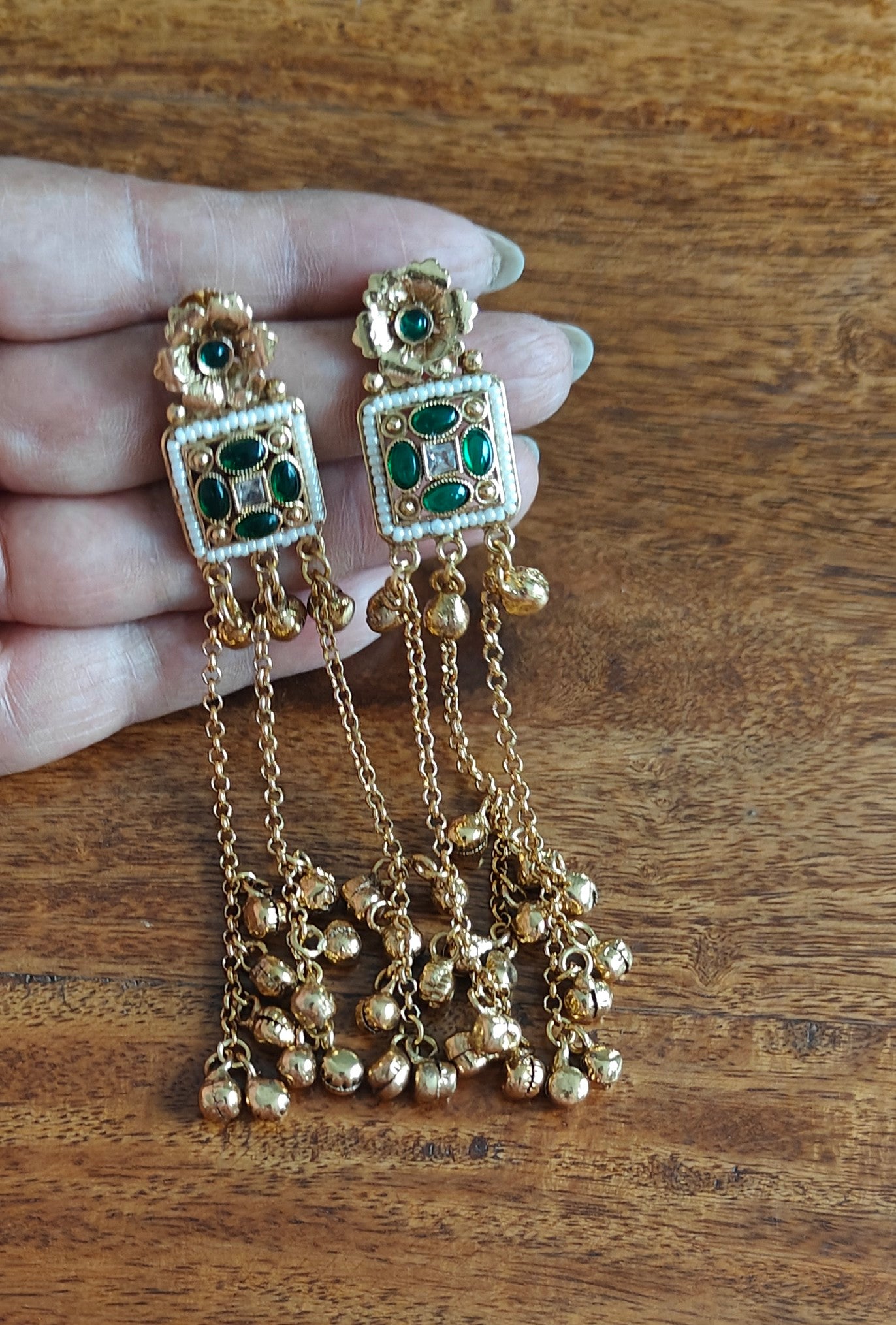 Gold earrings with hanging chains and gold balls below square with pearls and stone