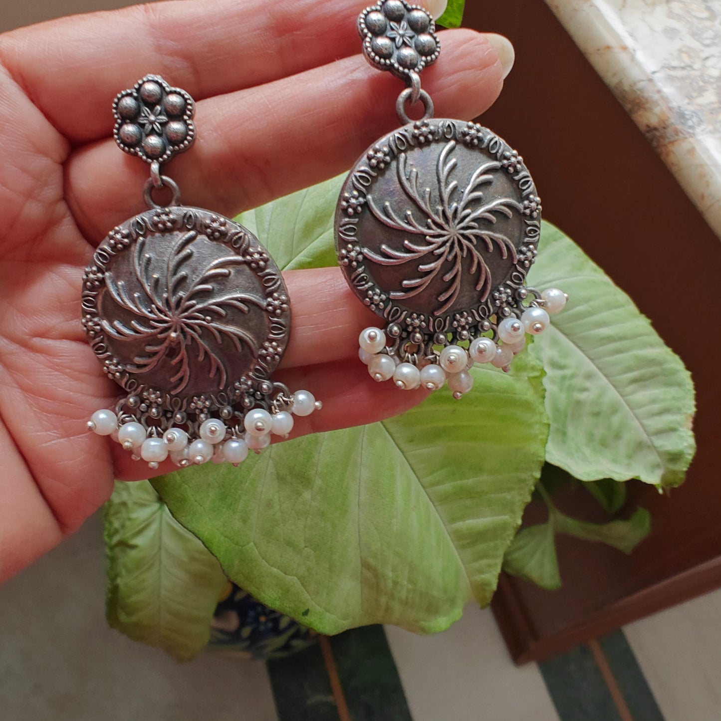 Engraved ferns on earrings and pearls below