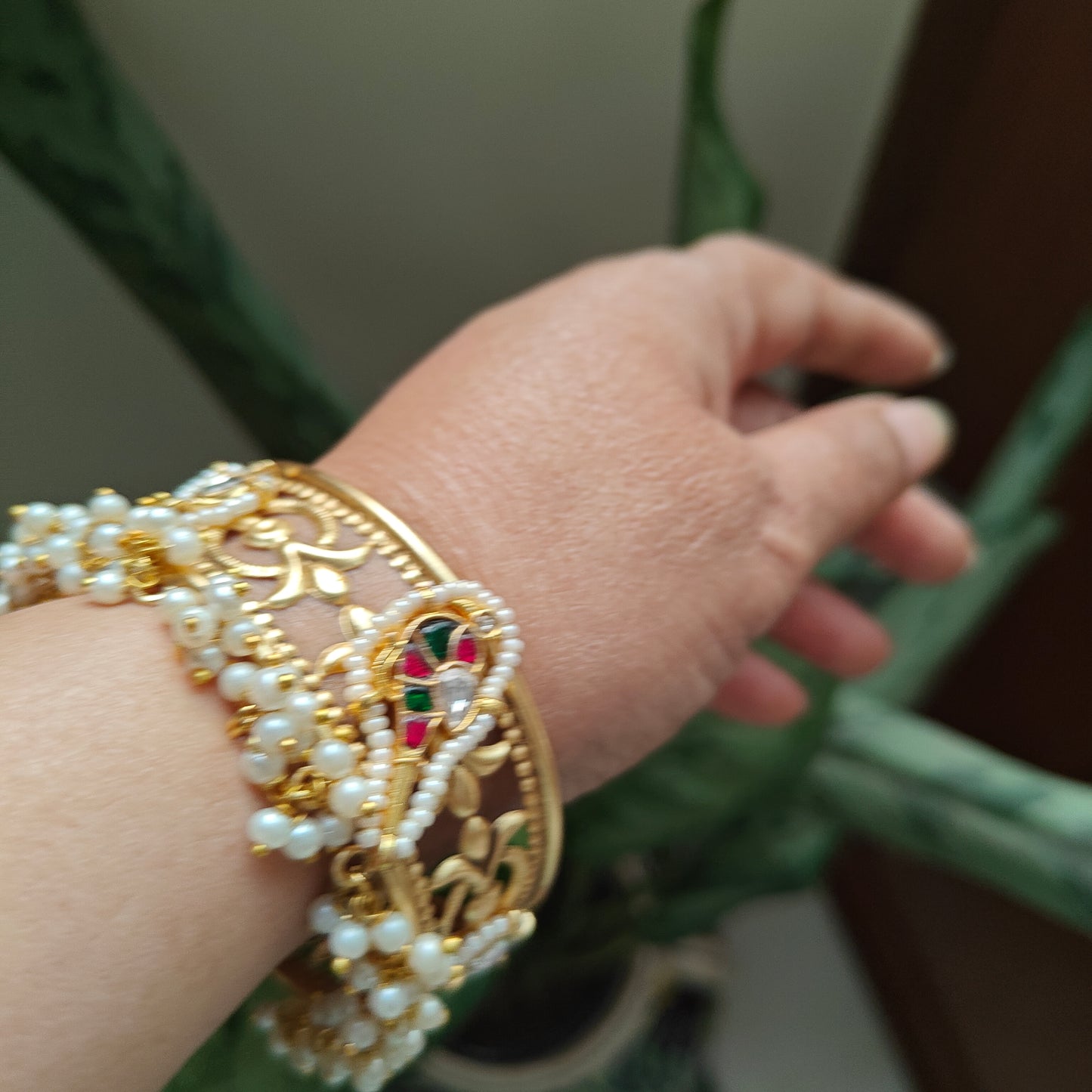 Golden kara with a bird motif and jali work