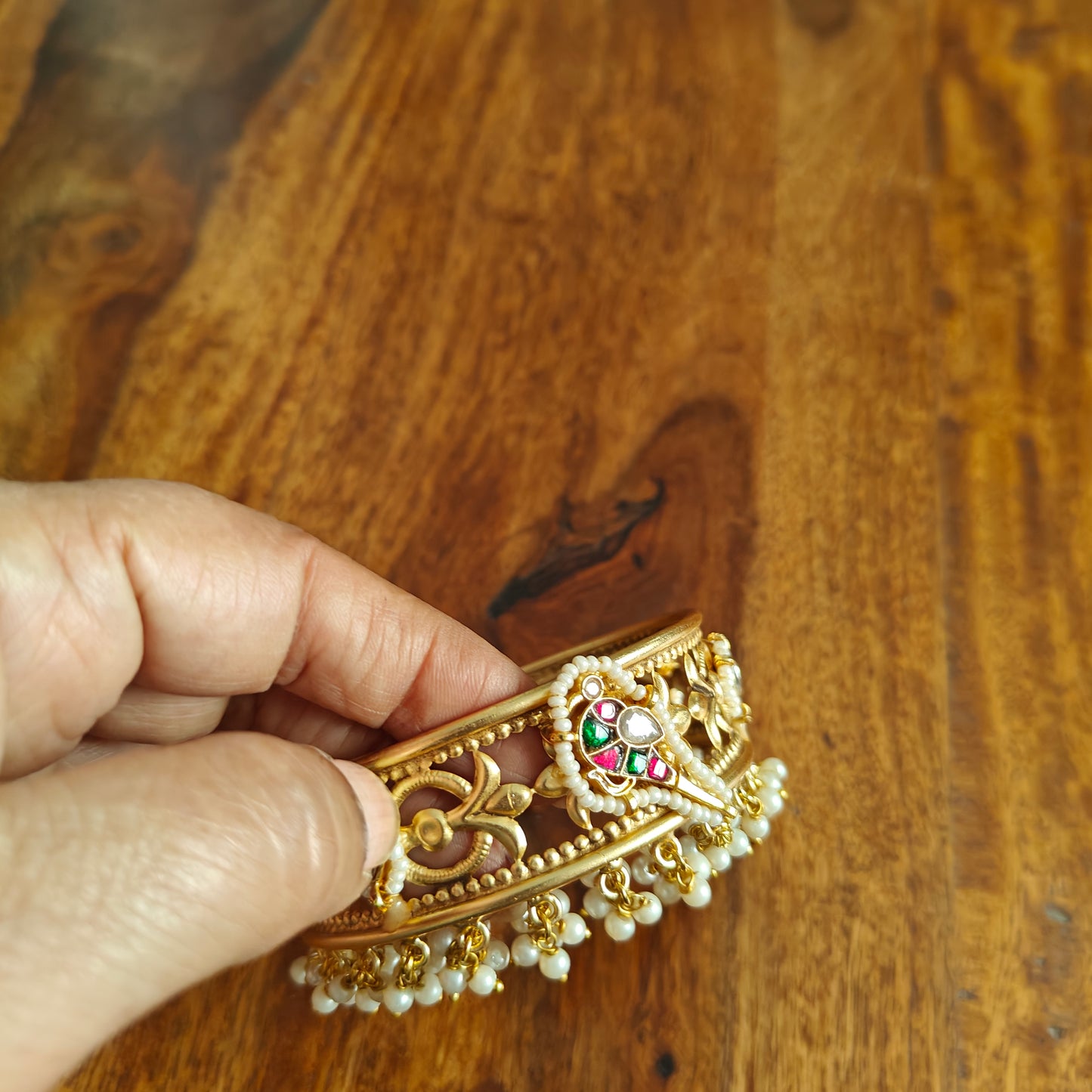 Golden kara with a bird motif and jali work