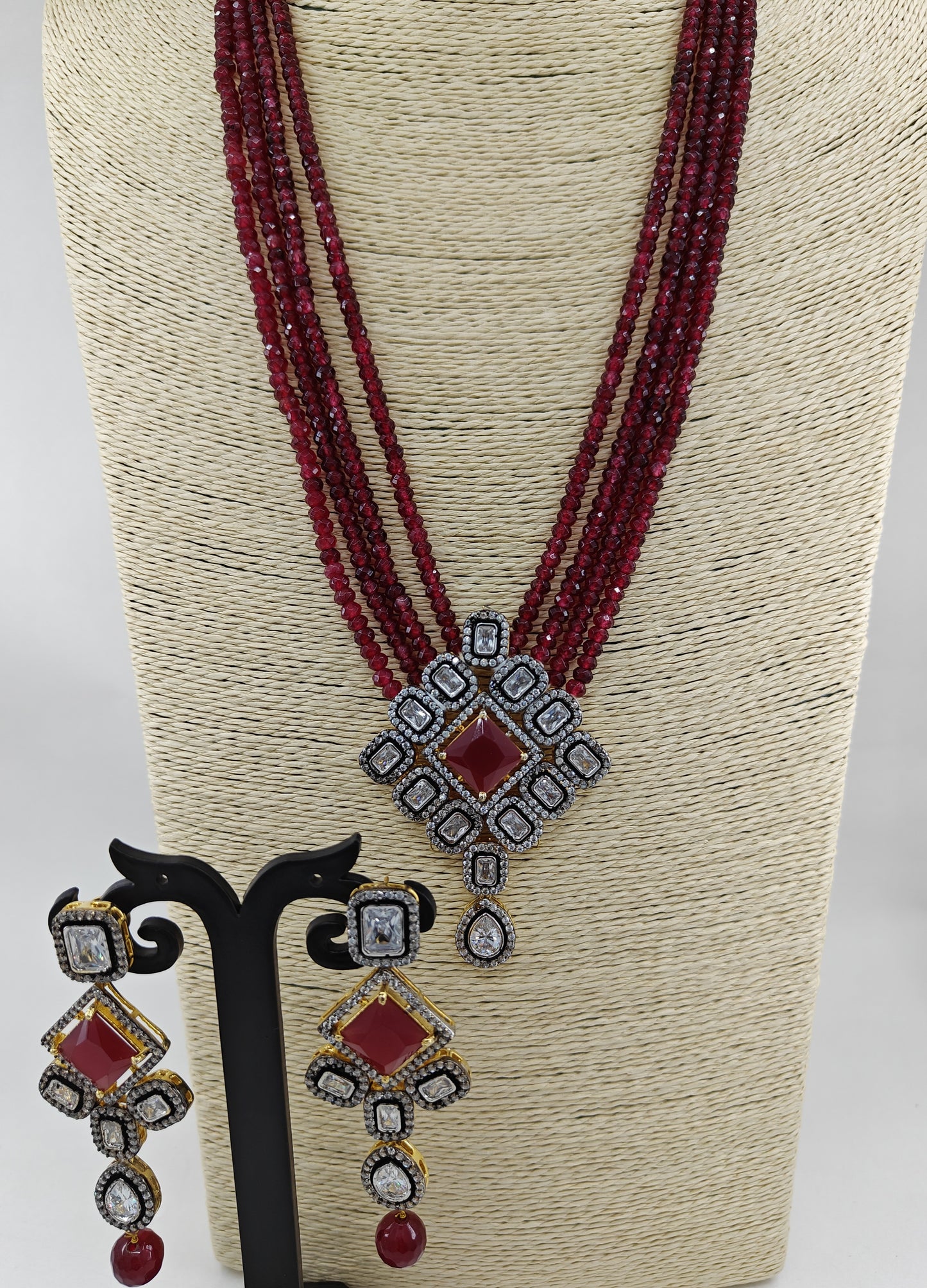 Set in antique finish,Pendant with CZ and red stone on red garnet strands,long earrings