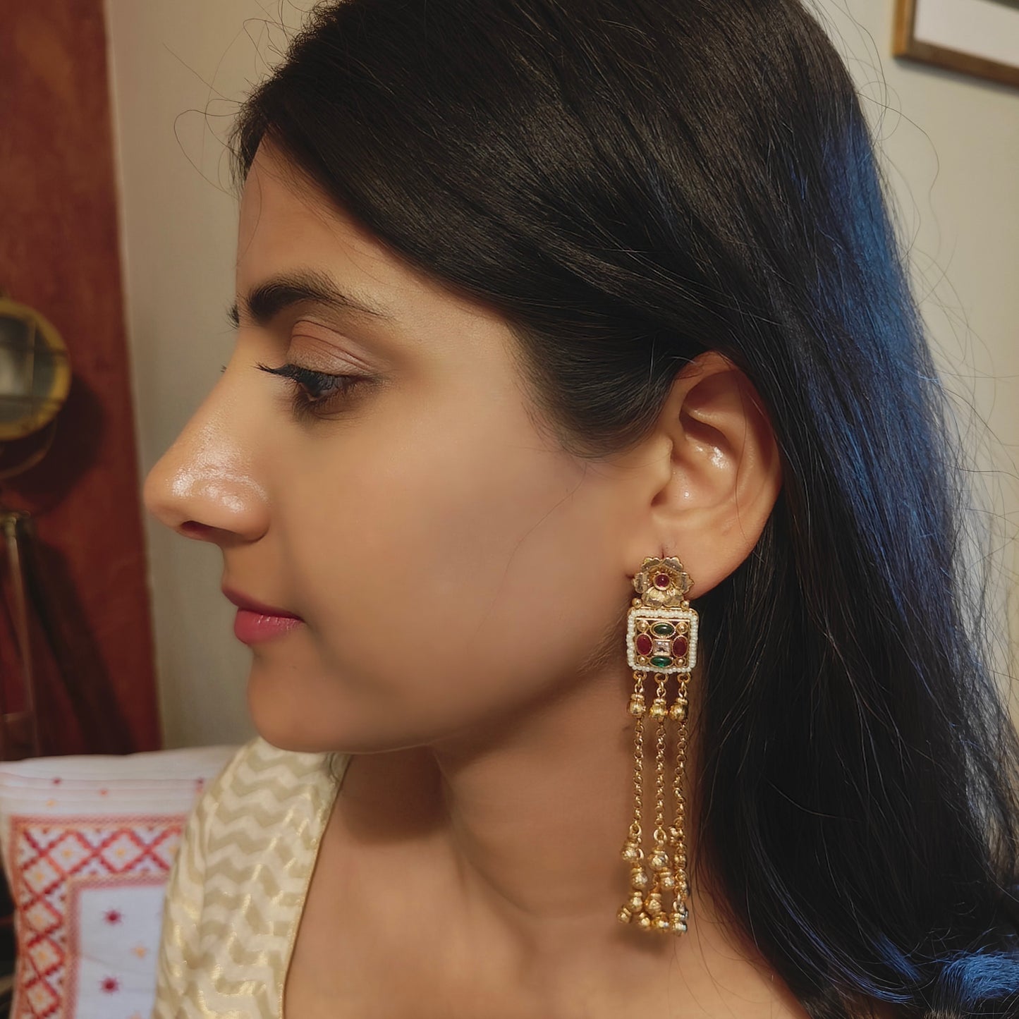 Gold earrings with hanging chains and gold balls below square with pearls and stone
