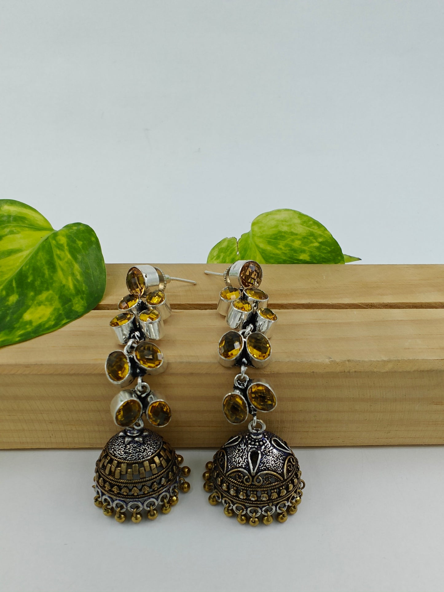 Silver/dual tone finish hanging jhumkis (earrings)on leaf dangler with stones