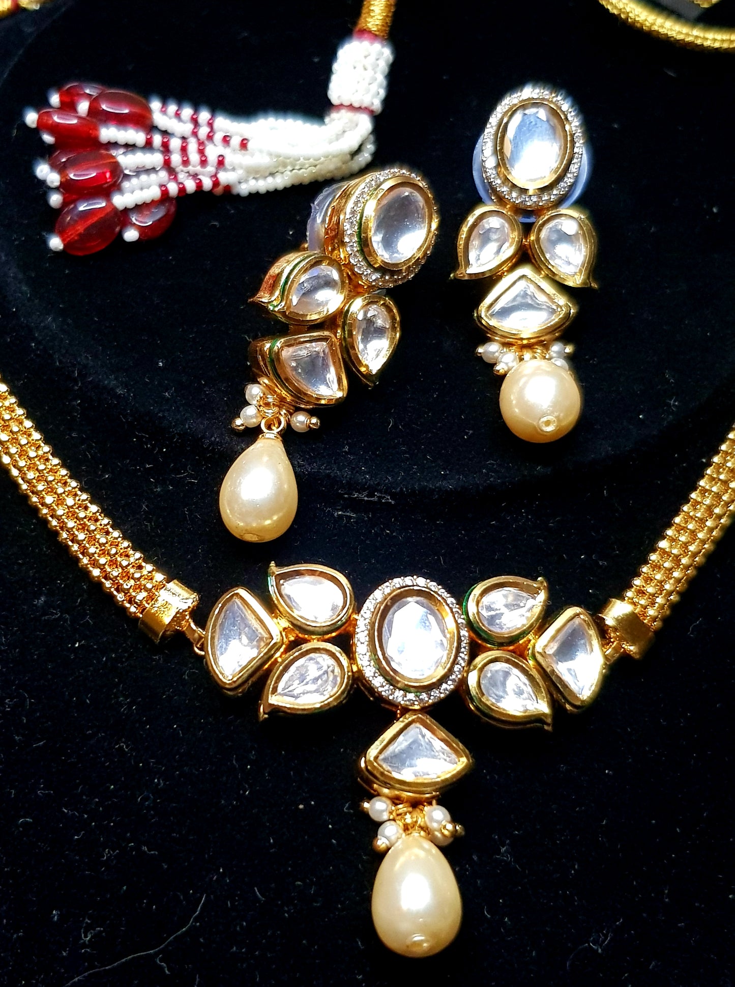 Kundan/red gemstone tikda with pearl/red gemstone drop on thin gold finish belt. Matching earrings.