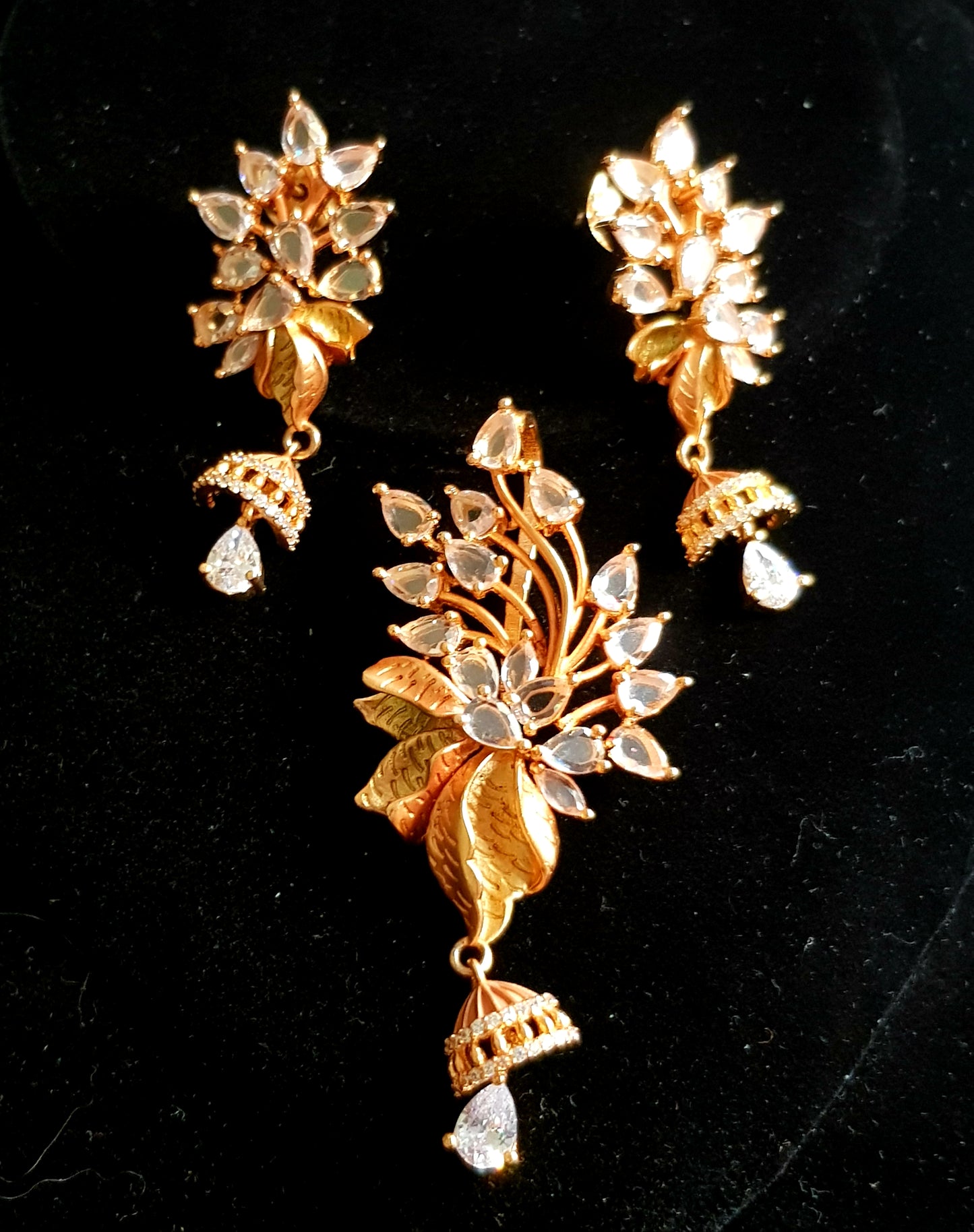 Gold finish flower design pendant set with clear stone and crystal hangings, matching earrings