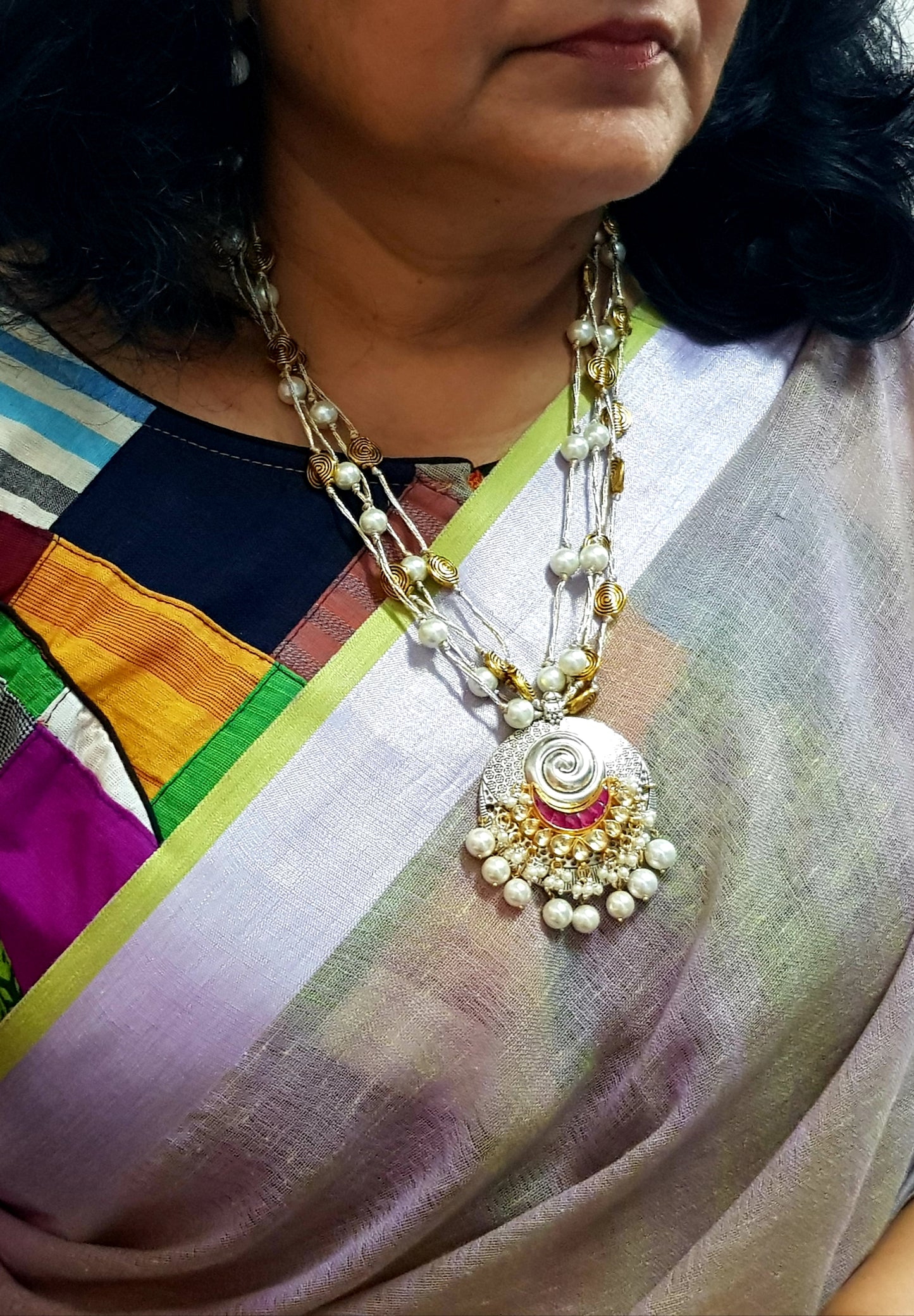 A funky set in silver finish with pearls and golden coils on multiple strings ,a pendant with red/green  stone,kundan and pearls,Big earring/jhumkis