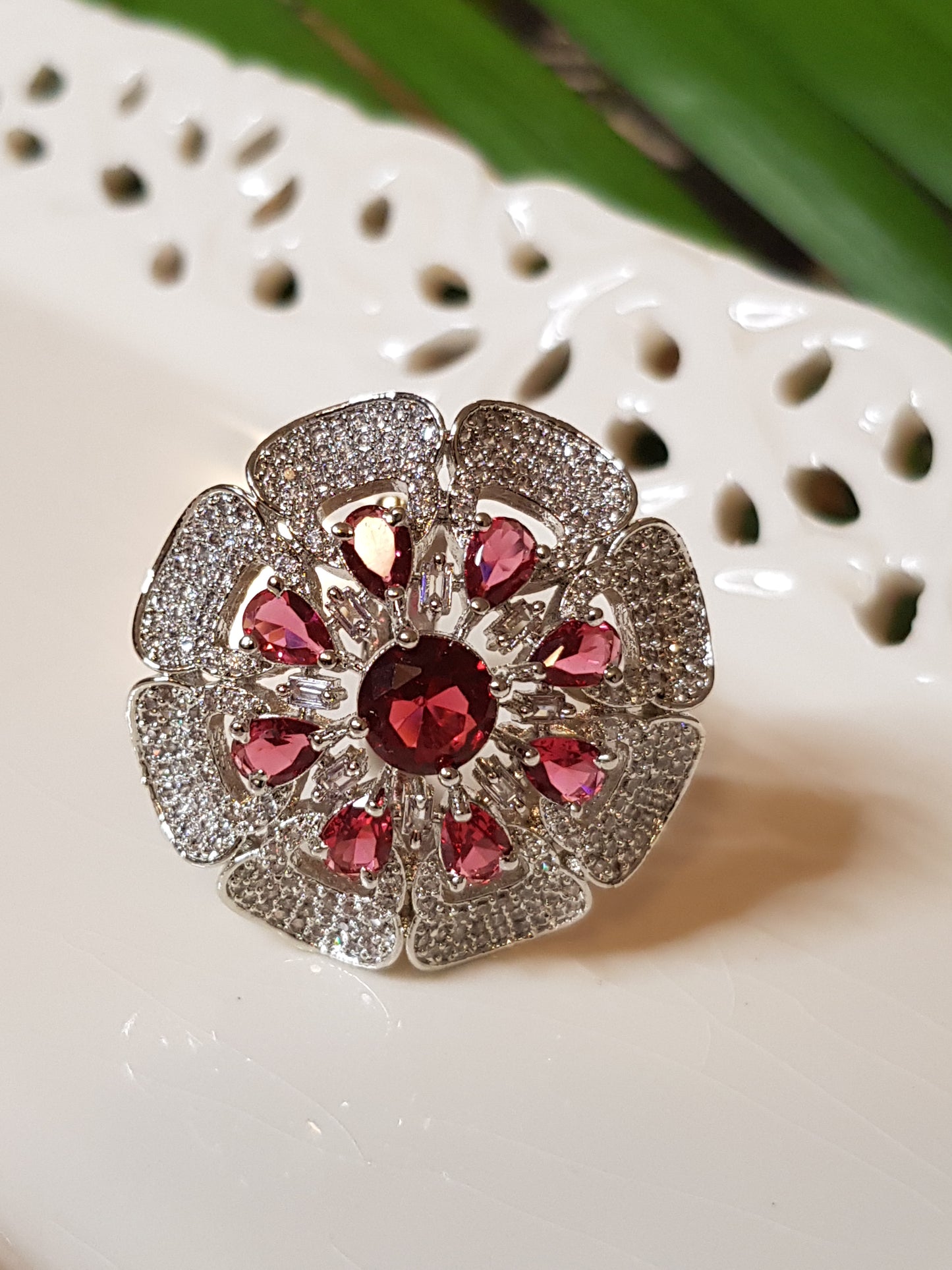 Antique finish ring, flower motif with ruby red stones and CZ detailing