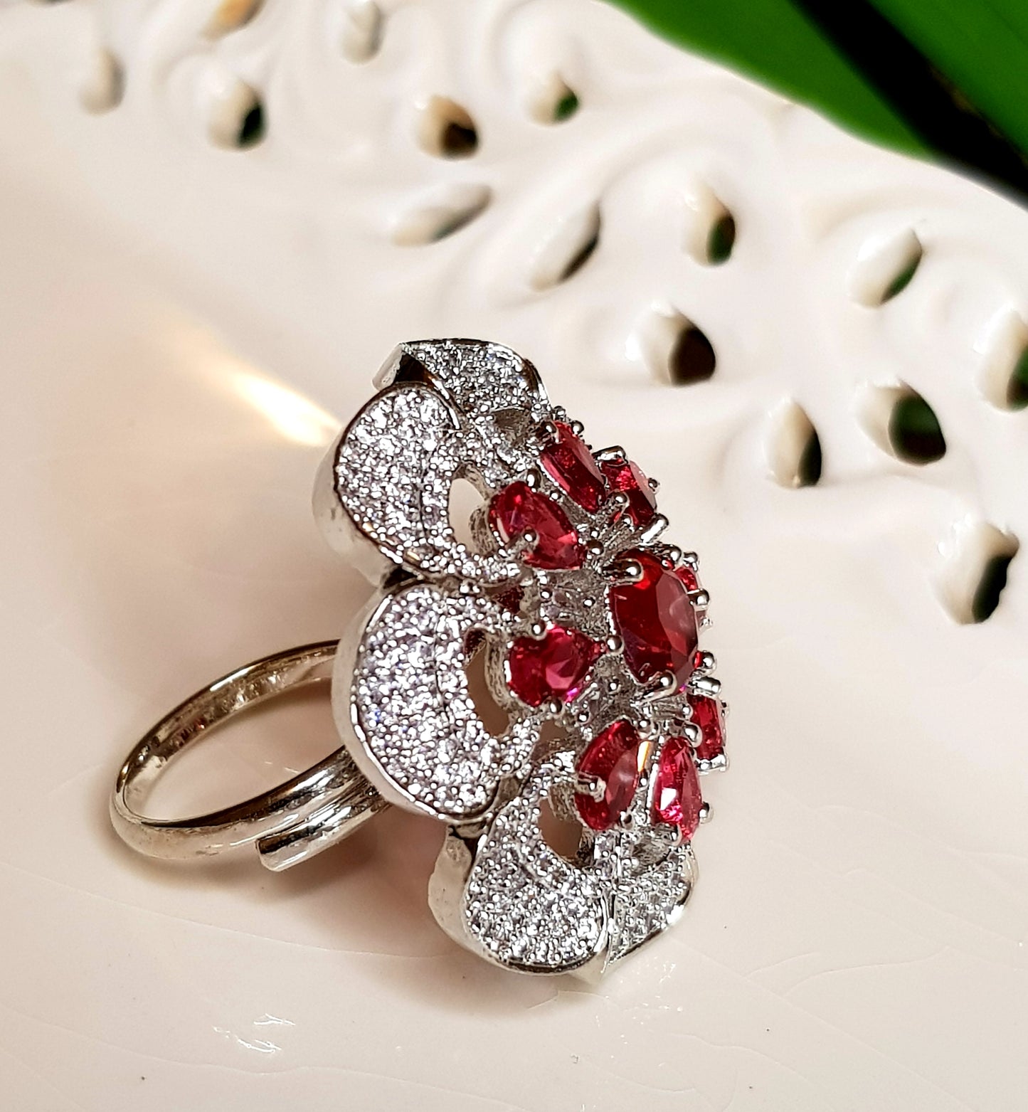 Antique finish ring, flower motif with ruby red stones and CZ detailing